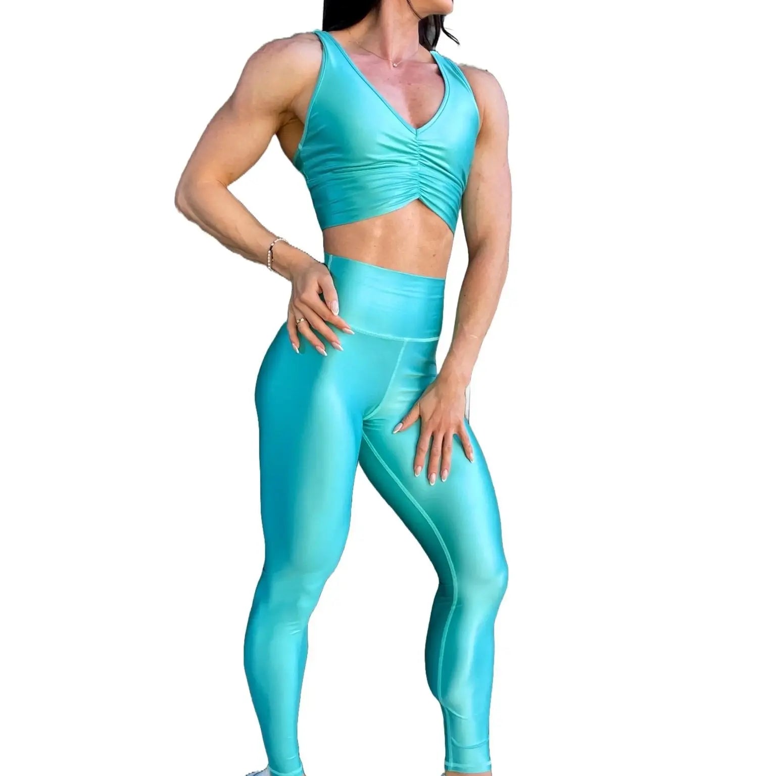 Mujer vistiendo el conjunto deportivo azul celeste de LUXFEEL, compuesto por el crop top brillante Adela Pearl Shine y el legging escultor Myself.