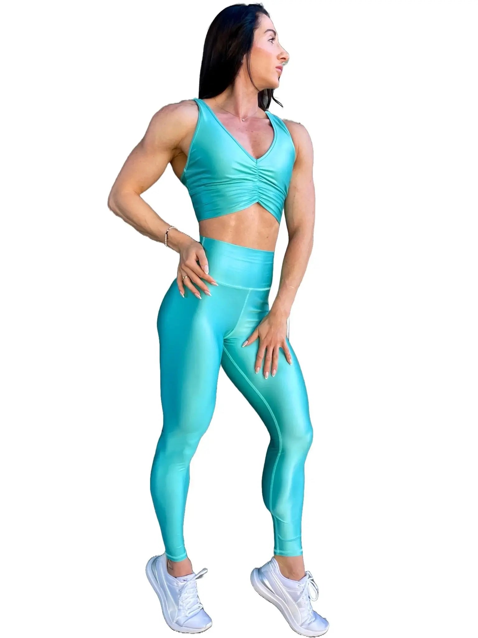 Mujer vistiendo el conjunto deportivo azul celeste de LUXFEEL, compuesto por el crop top brillante Adela Pearl Shine y el legging escultor Myself.