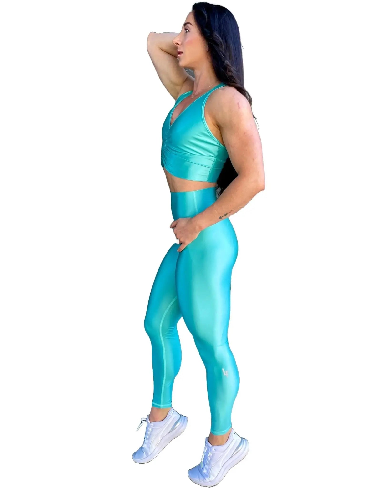 Mujer vistiendo el conjunto deportivo azul celeste de LUXFEEL, compuesto por el crop top brillante Adela Pearl Shine y el legging escultor Myself.