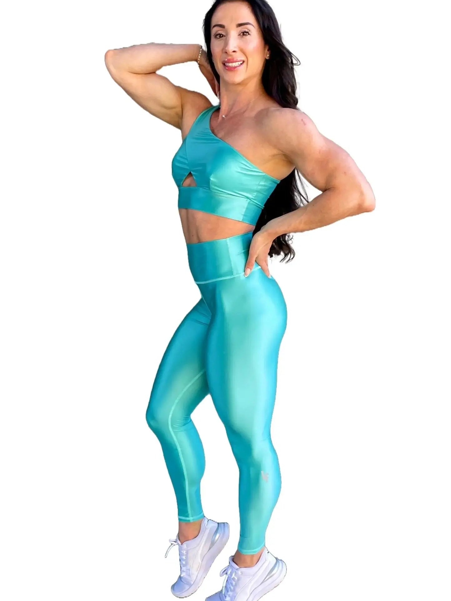 Mujer vistiendo el conjunto azul celeste brillante de LUXFEEL, compuesto por el top asimétrico Carmela (un solo hombro y apertura en el escote) y el legging Pearl Shine a juego.