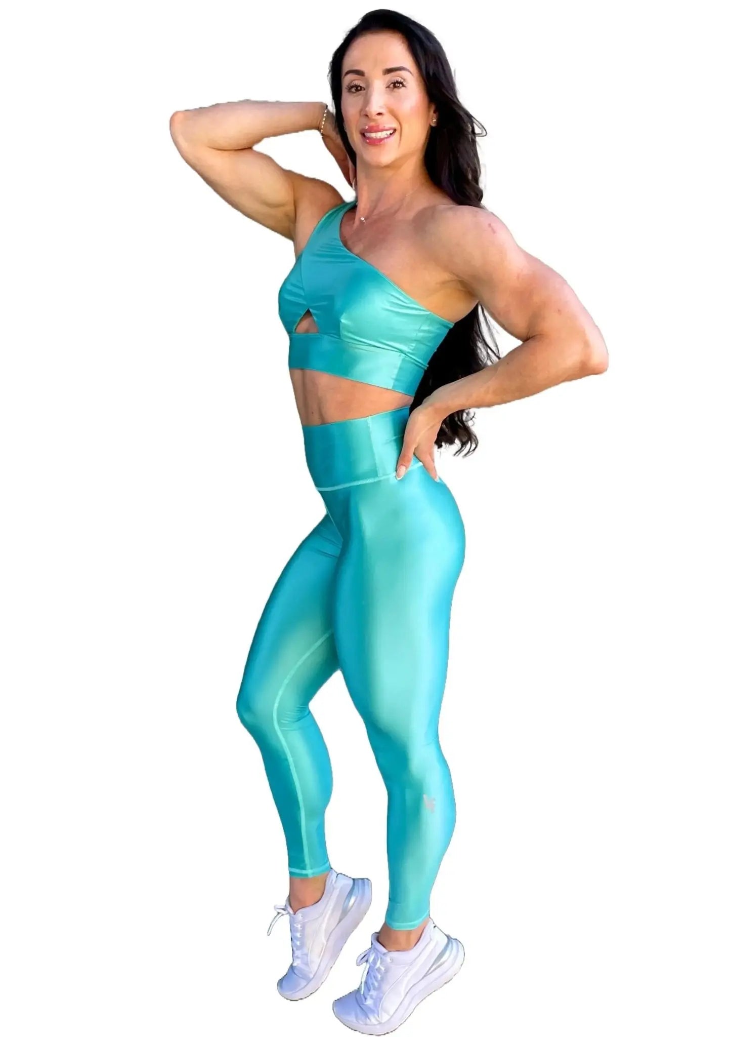 Mujer vistiendo el conjunto azul celeste brillante de LUXFEEL, compuesto por el top asimétrico Carmela (un solo hombro y apertura en el escote) y el legging Pearl Shine a juego.