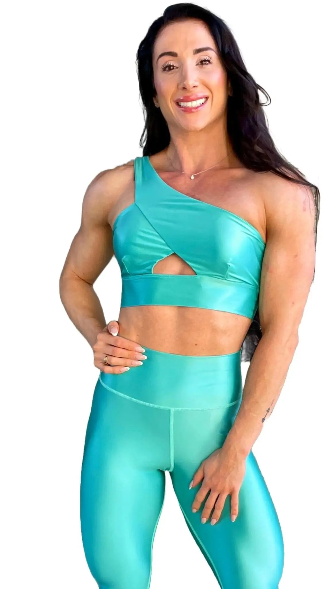 Mujer vistiendo el conjunto azul celeste brillante de LUXFEEL, compuesto por el top asimétrico Carmela (un solo hombro y apertura en el escote) y el legging Pearl Shine a juego.