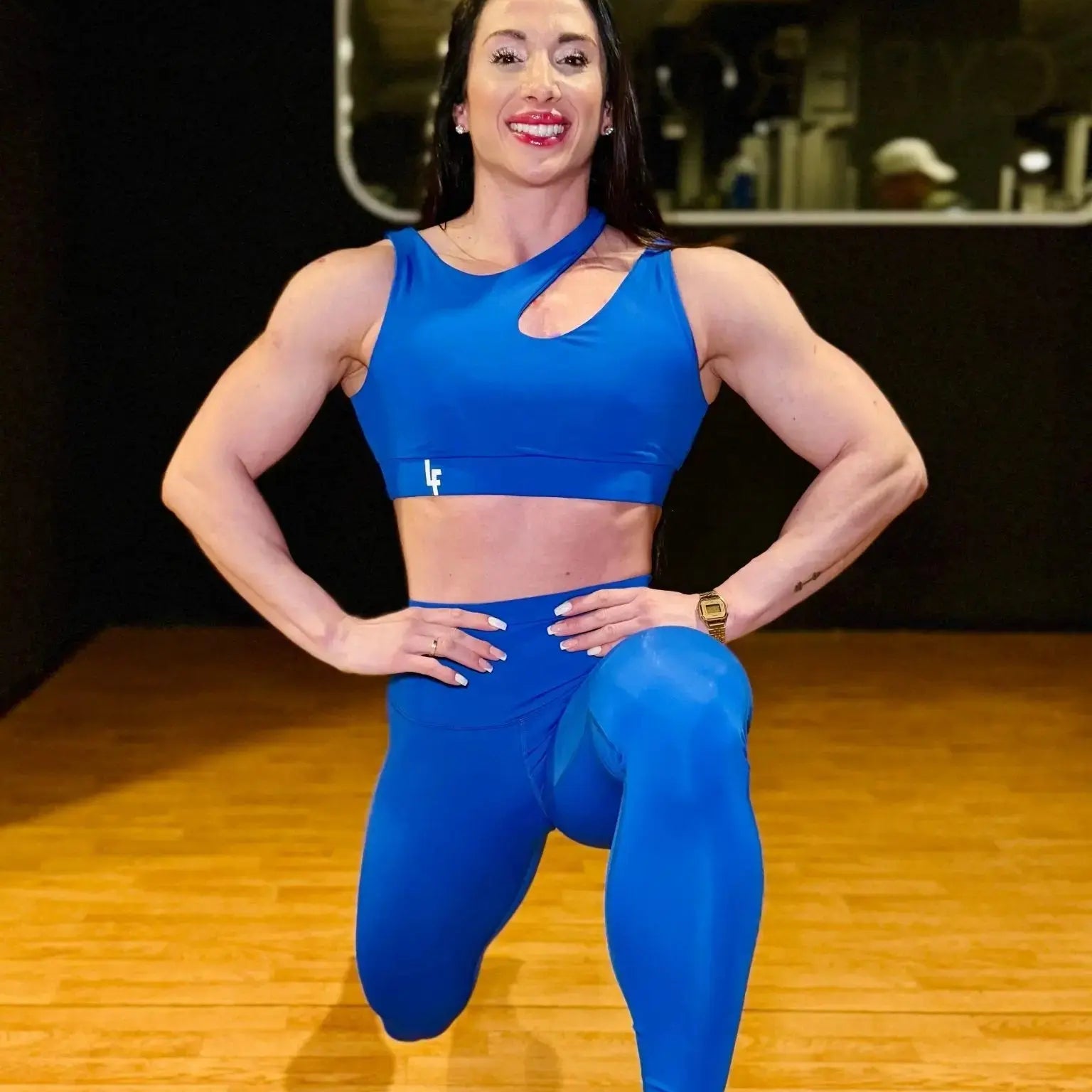 Mujer vistiendo el conjunto deportivo azul de LUXFEEL, compuesto por el top asimétrico Vanesa y el legging escultor Myself.