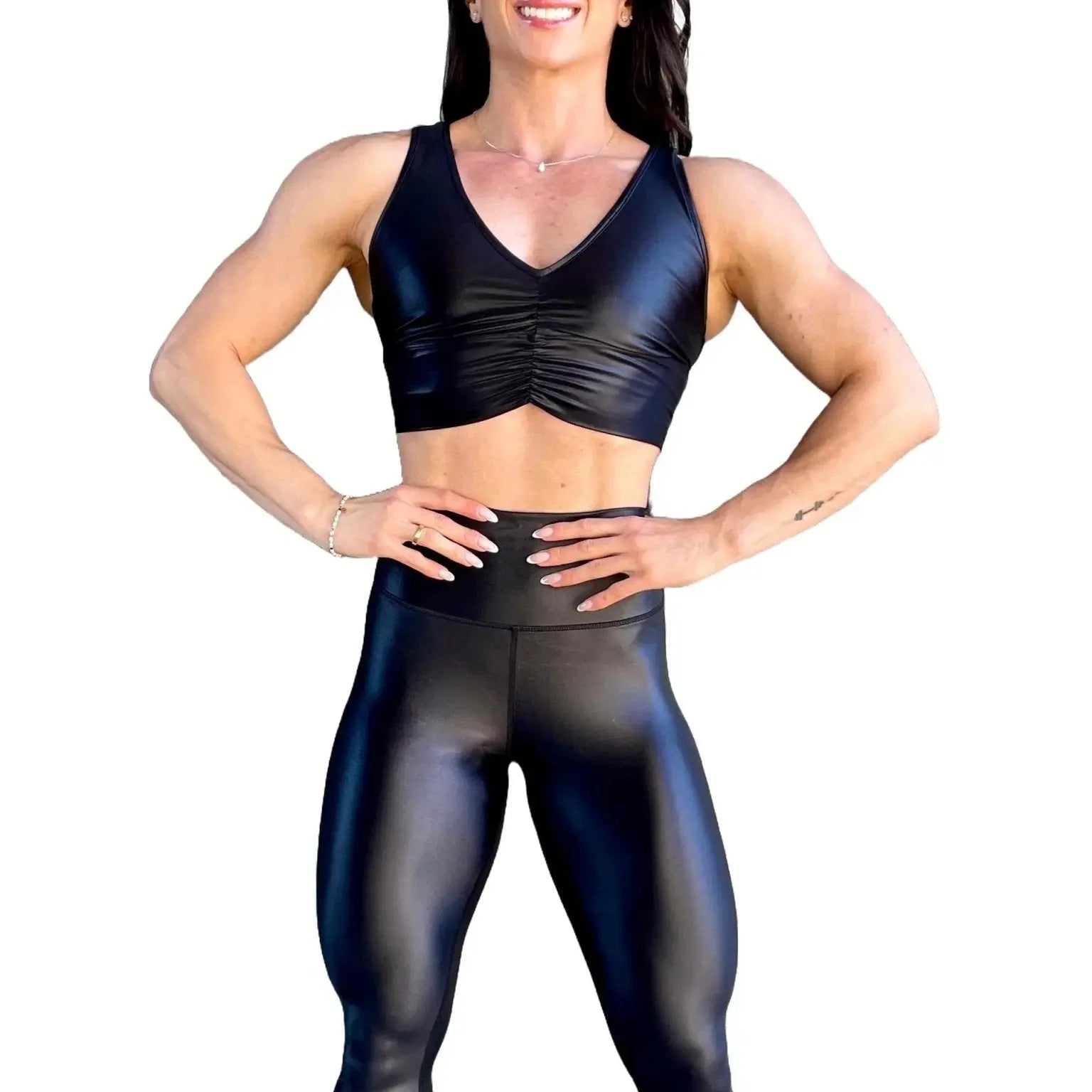 Mujer vistiendo el crop top brillante Top Adela Pearl Shine de LUXFEEL en color Negro Brillante, con escote en V y detalle fruncido en el pecho.