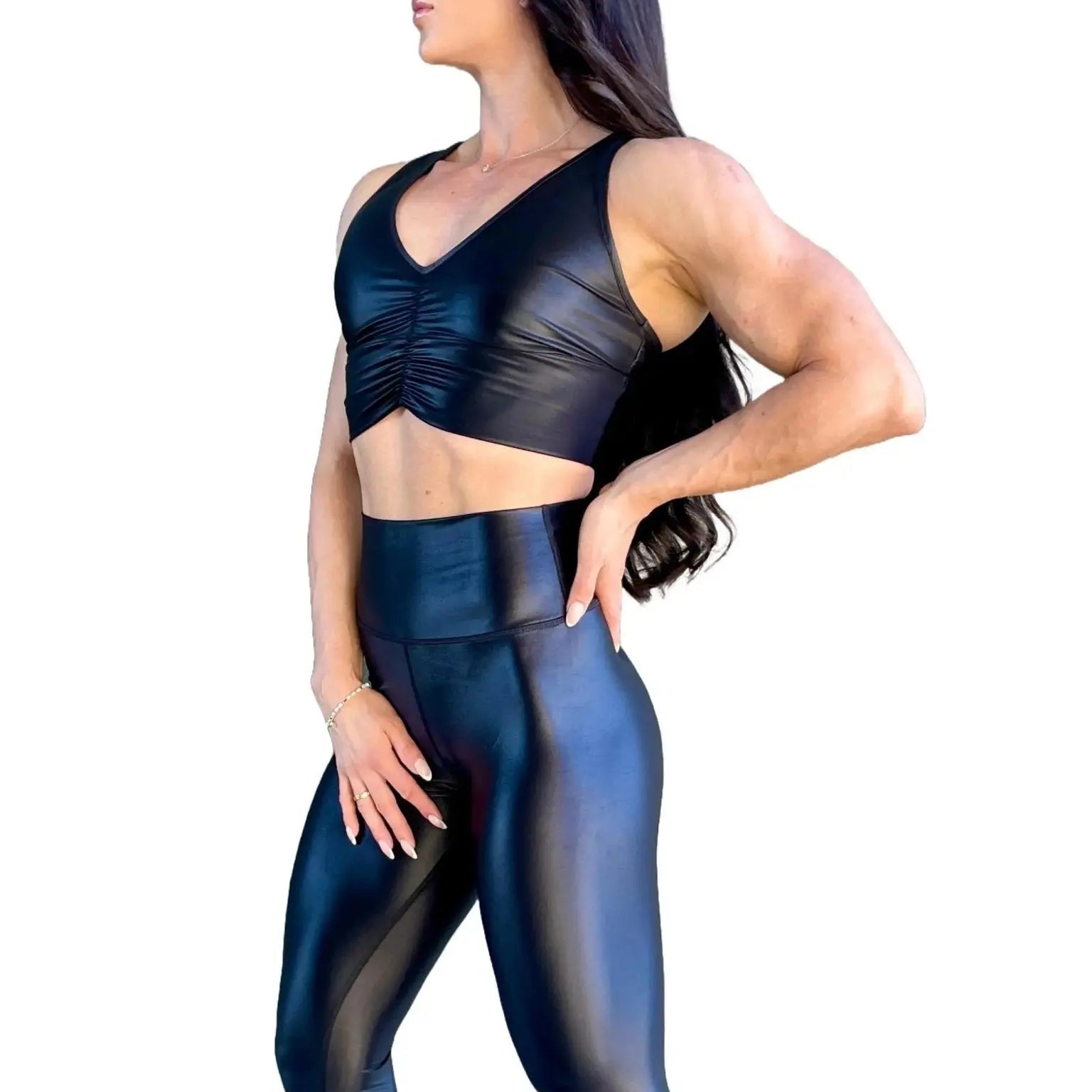 Mujer vistiendo el crop top brillante Top Adela Pearl Shine de LUXFEEL en color Negro Brillante, con escote en V y detalle fruncido en el pecho.