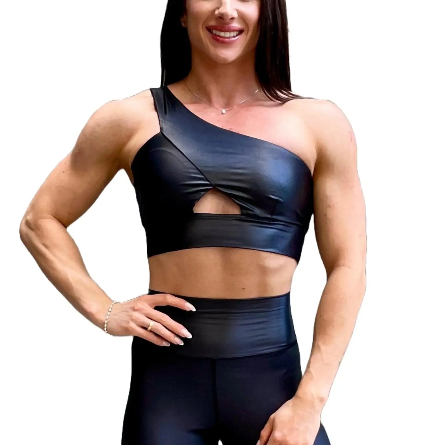 Mujer vistiendo el conjunto deportivo negro brillante de LUXFEEL, compuesto por el top asimétrico Carmela y el legging Pearl Shine