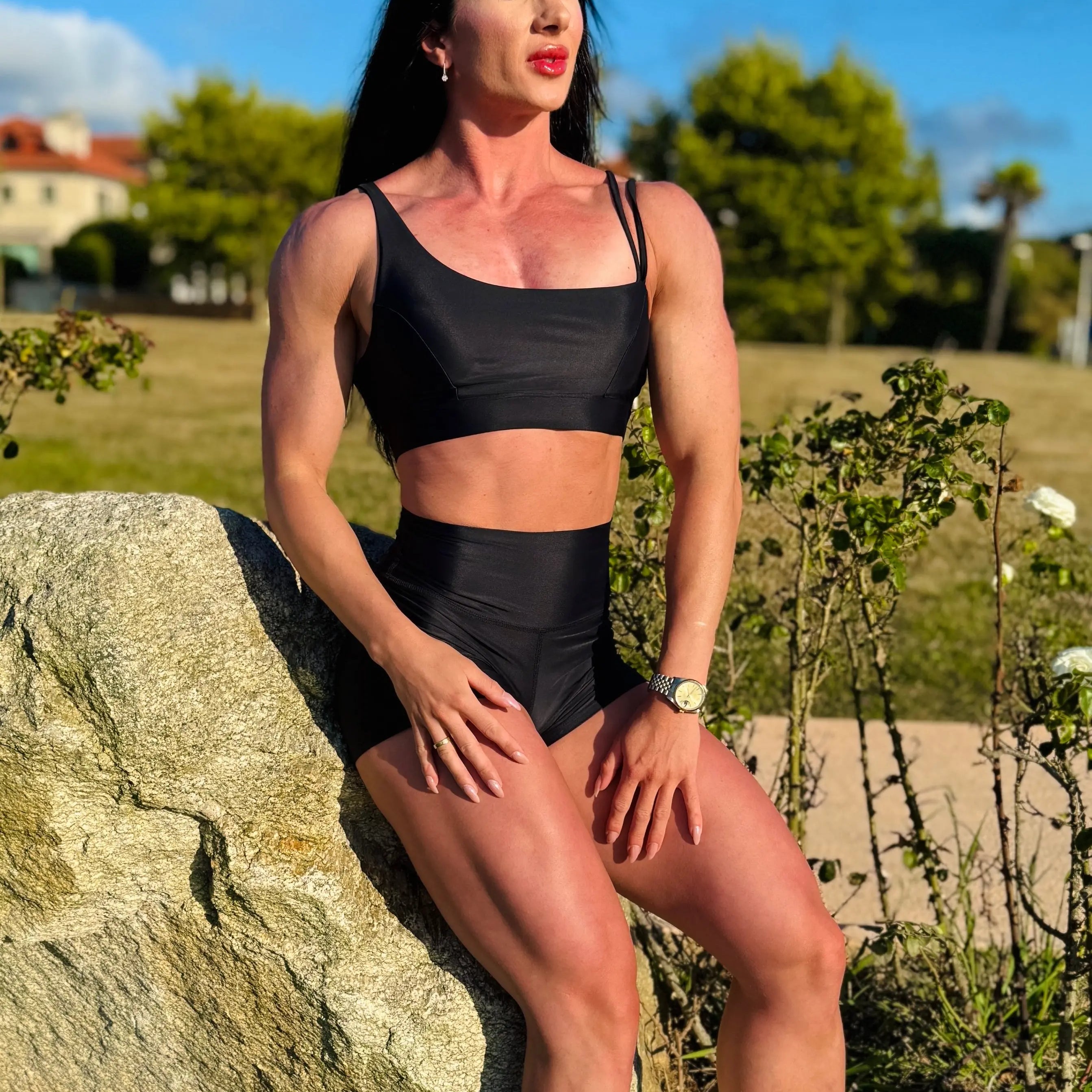 Modelo sentada en una piedra mostrando el conjunto Negro (Top Valentina y Short) - LUXFEEL