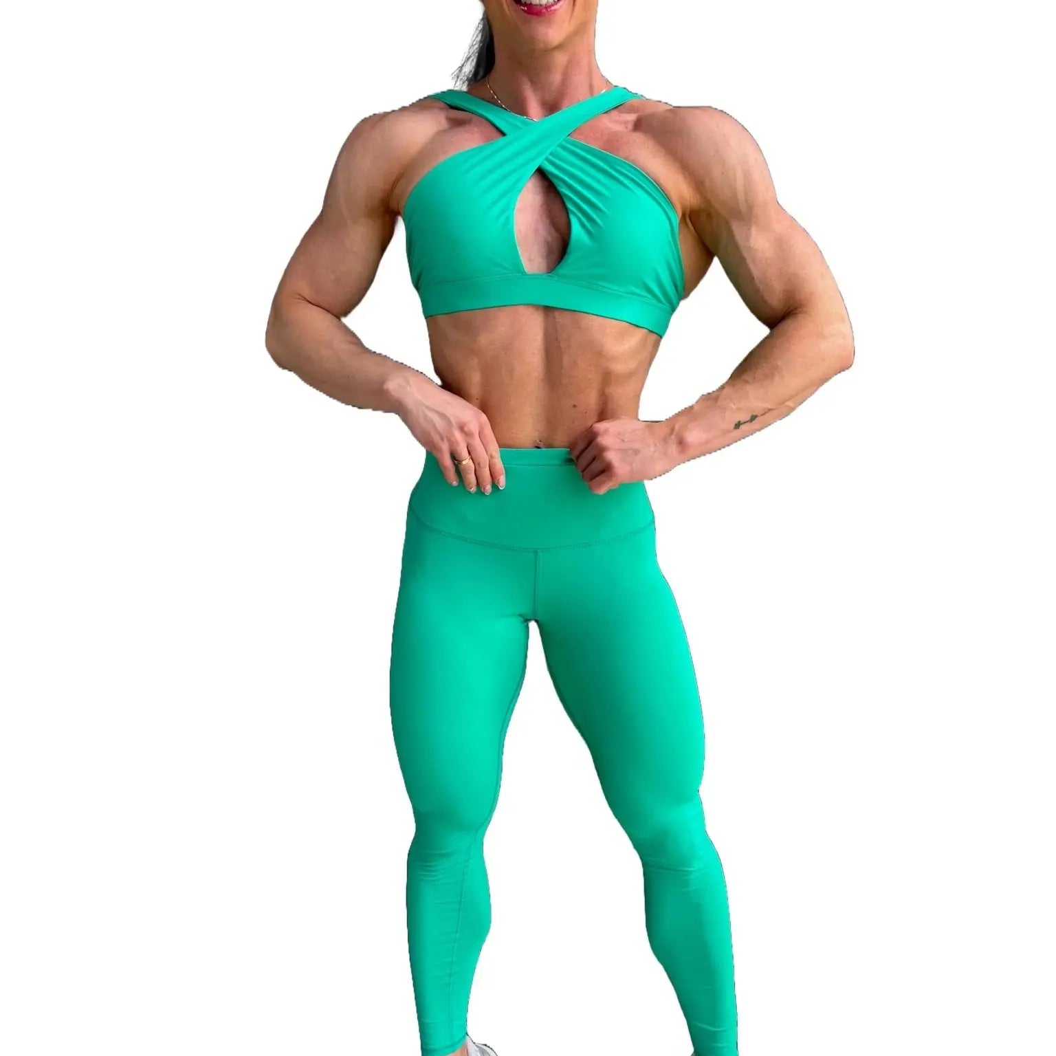 Modelo luciendo el conjunto verde de Top Paula y Legging Myself, mostrando el top con su diseño de tirantes cruzados para mayor sujeción.