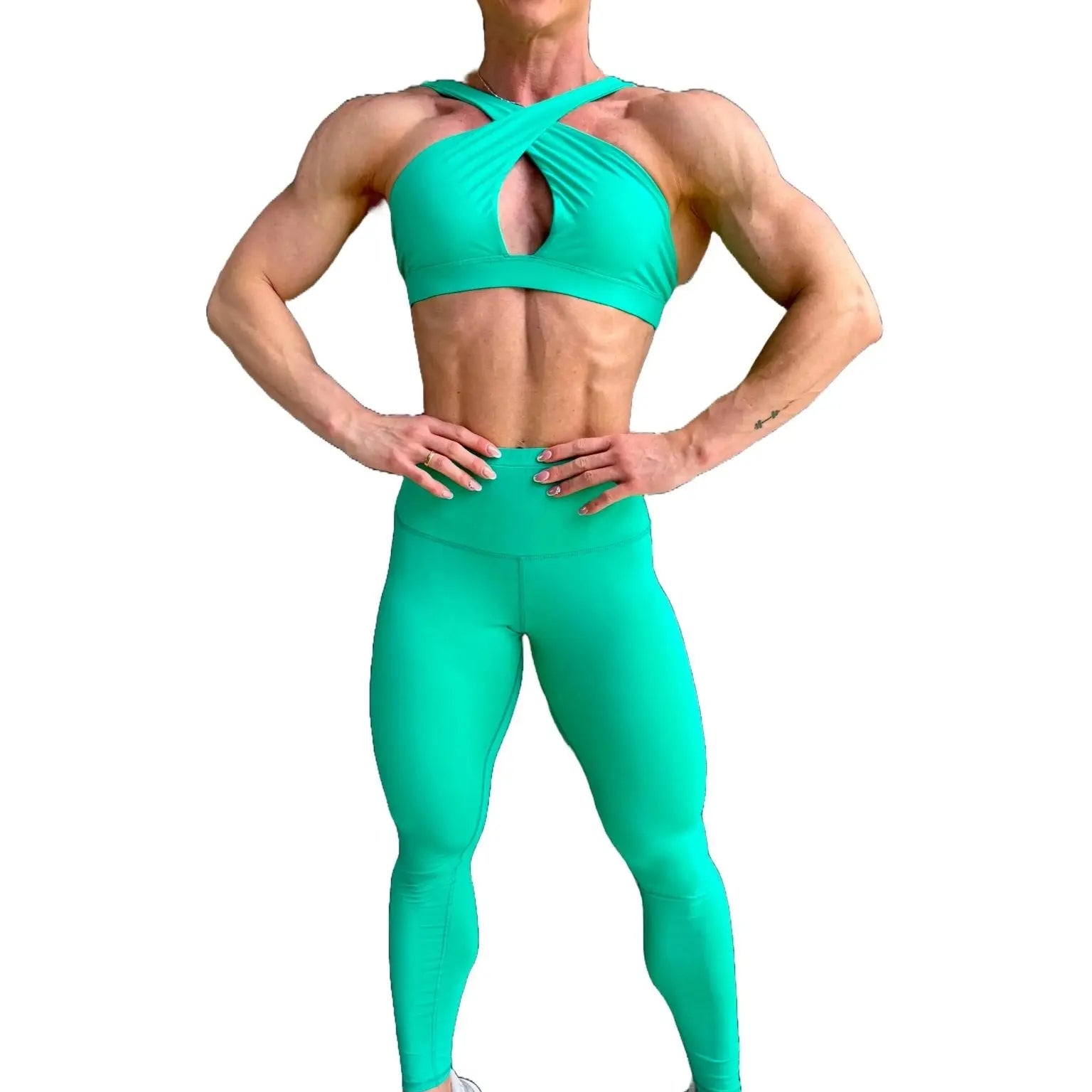 Modelo luciendo el conjunto verde de Top Paula y Legging Myself, mostrando el top con su diseño de tirantes cruzados para mayor sujeción.