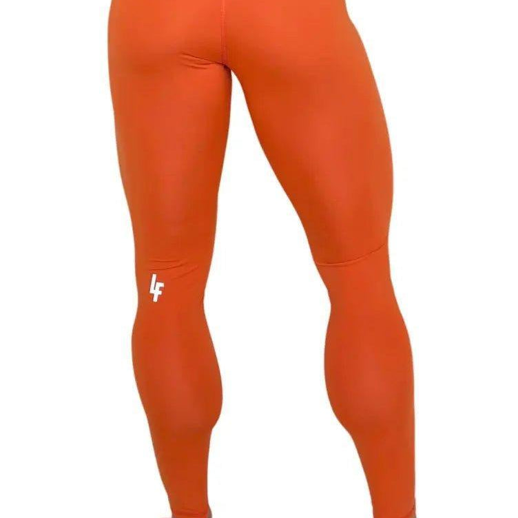 Mujer vistiendo los leggings compresivos de cintura alta Legging Myself de LUXFEEL en color Naranja, que ofrecen un efecto segunda piel.