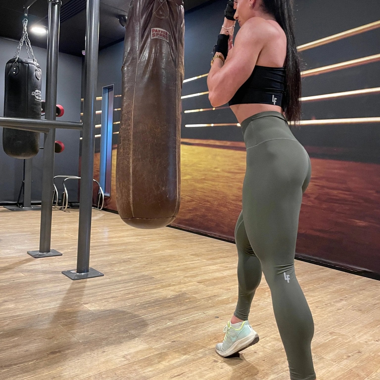 Mujer vistiendo los leggings compresivos de cintura alta Legging Myself de LUXFEEL en color Verde Caqui / Verde Kaki, que ofrecen un efecto segunda piel.