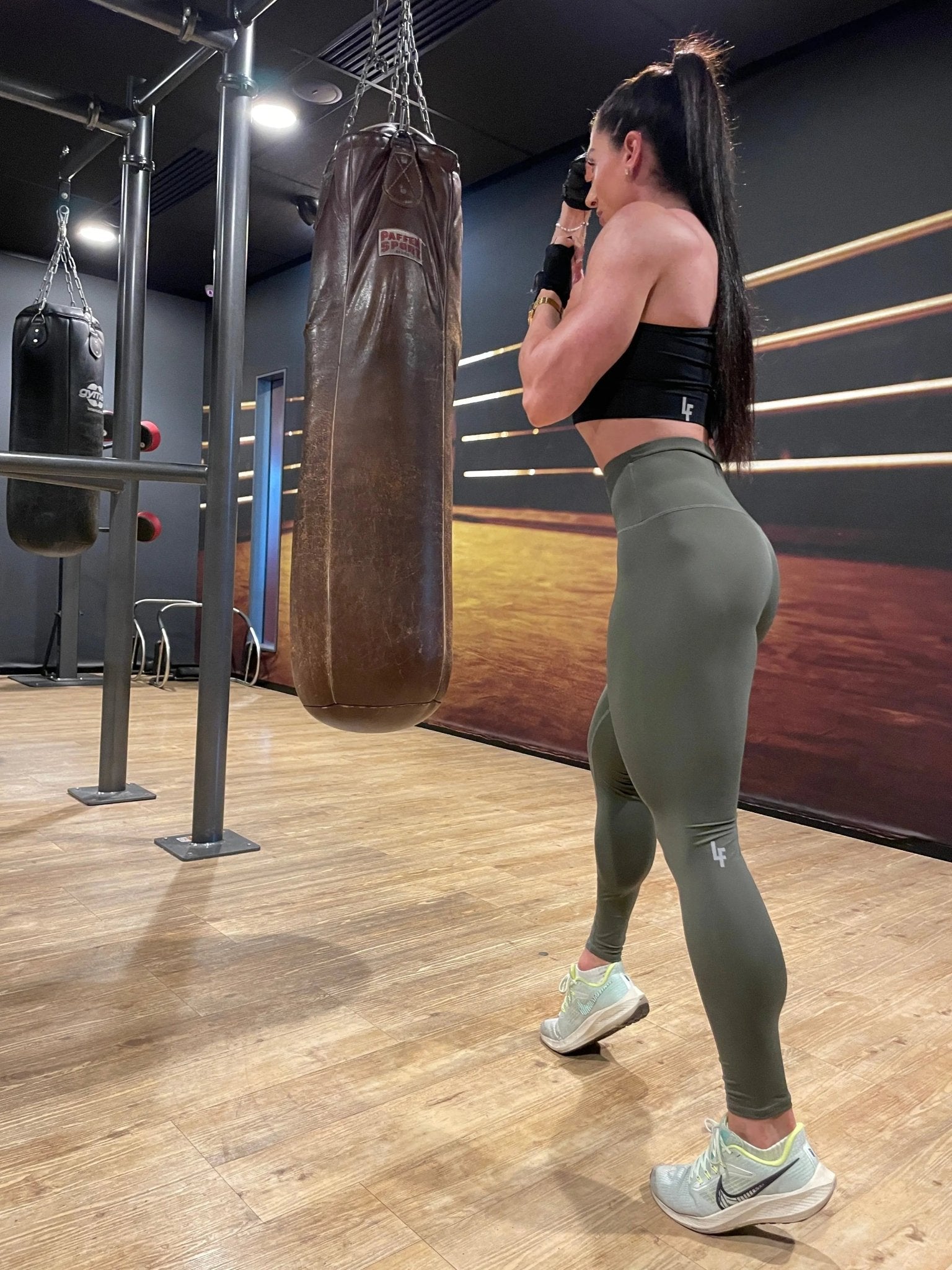 Mujer vistiendo los leggings compresivos de cintura alta Legging Myself de LUXFEEL en color Verde Caqui / Verde Kaki, que ofrecen un efecto segunda piel.