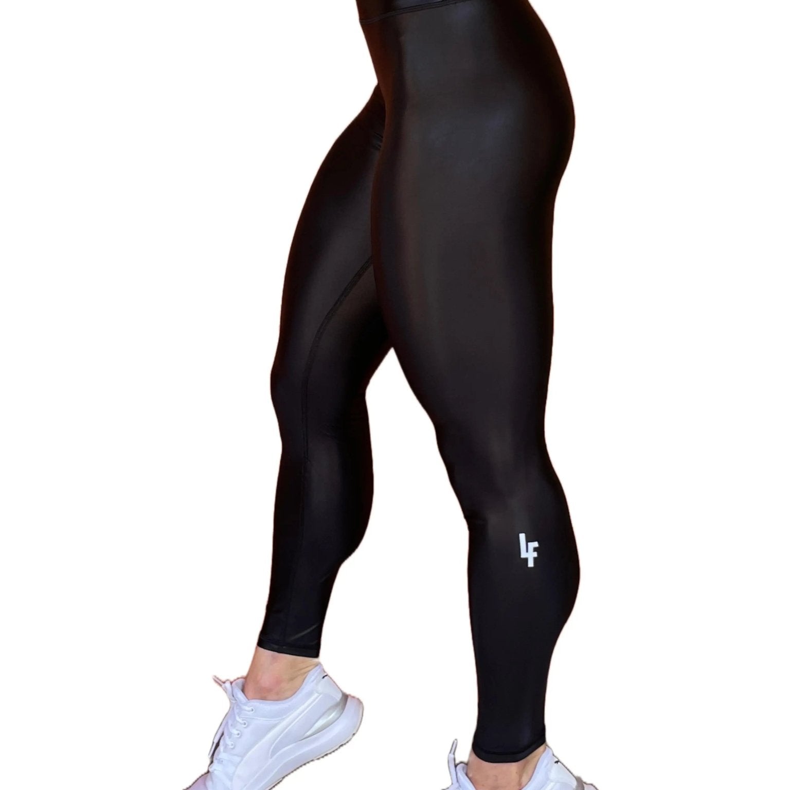 Mujer vistiendo los leggings brillantes de cintura alta Legging Pearl Shine de LUXFEEL en color Negro Brillante, con acabado efecto perla.