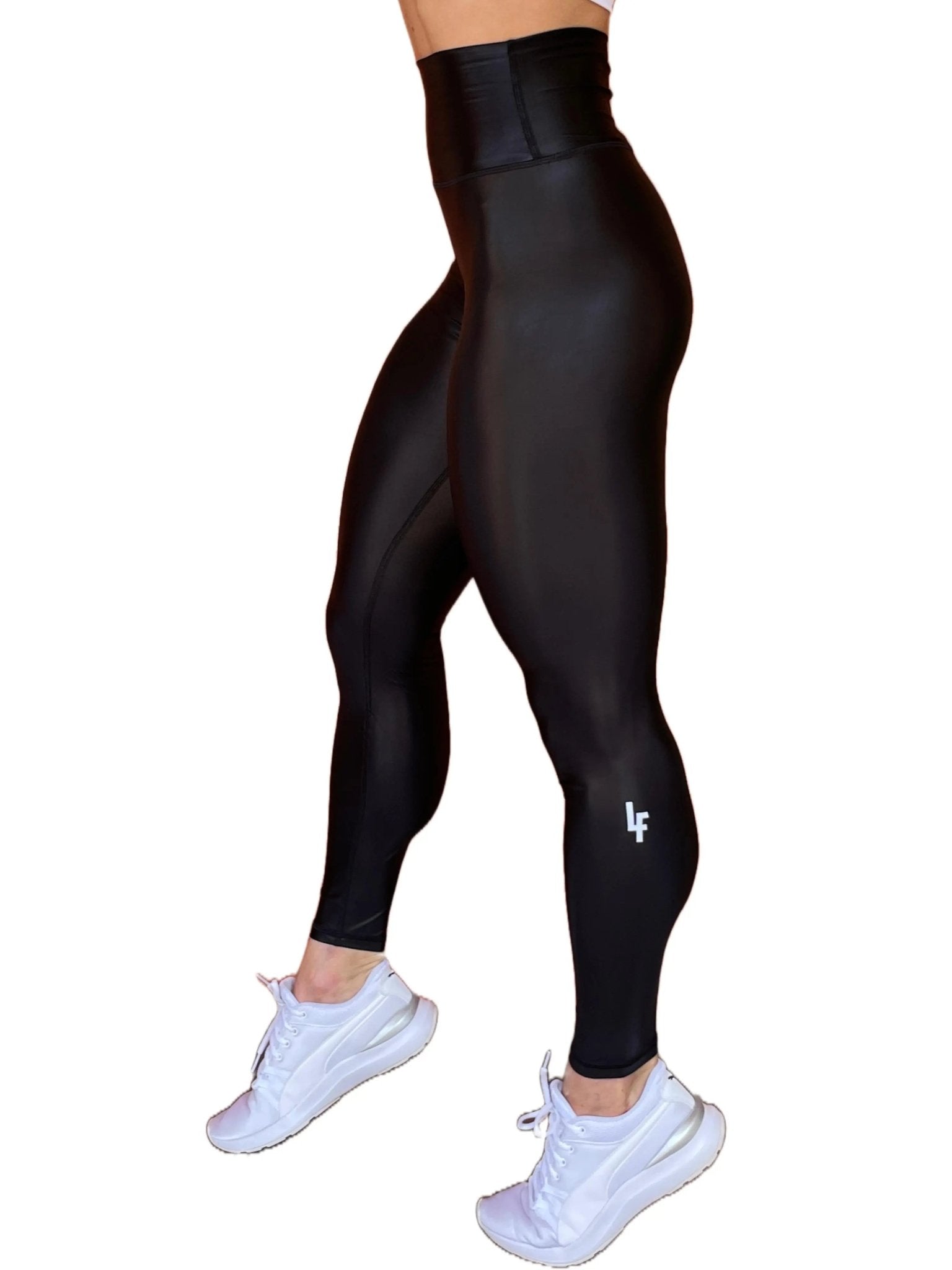 Mujer vistiendo los leggings brillantes de cintura alta Legging Pearl Shine de LUXFEEL en color Negro Brillante, con acabado efecto perla.