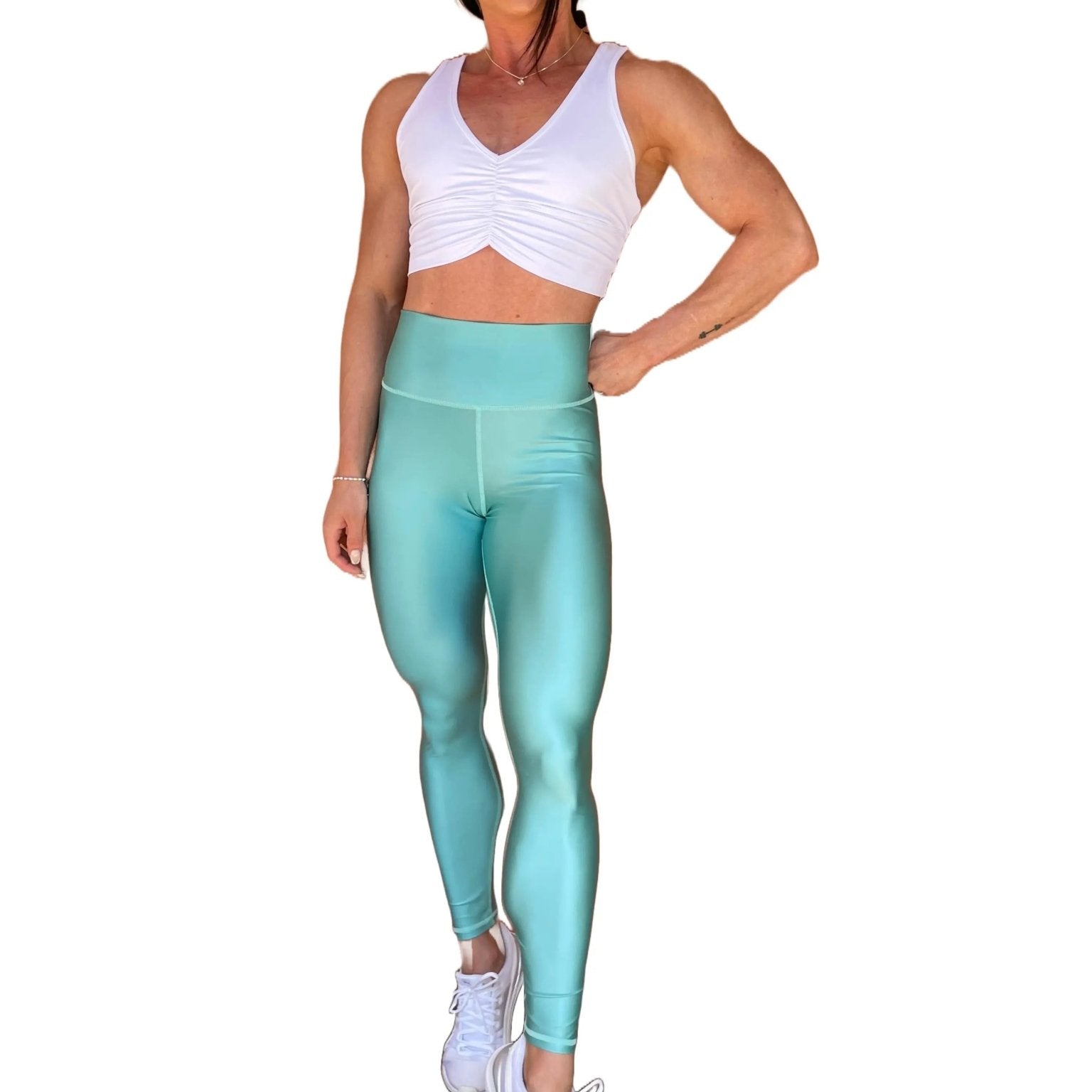 Mujer vistiendo los leggings brillantes de cintura alta Legging Pearl Shine de LUXFEEL en color Azul Celeste Brillante, con acabado efecto perla.