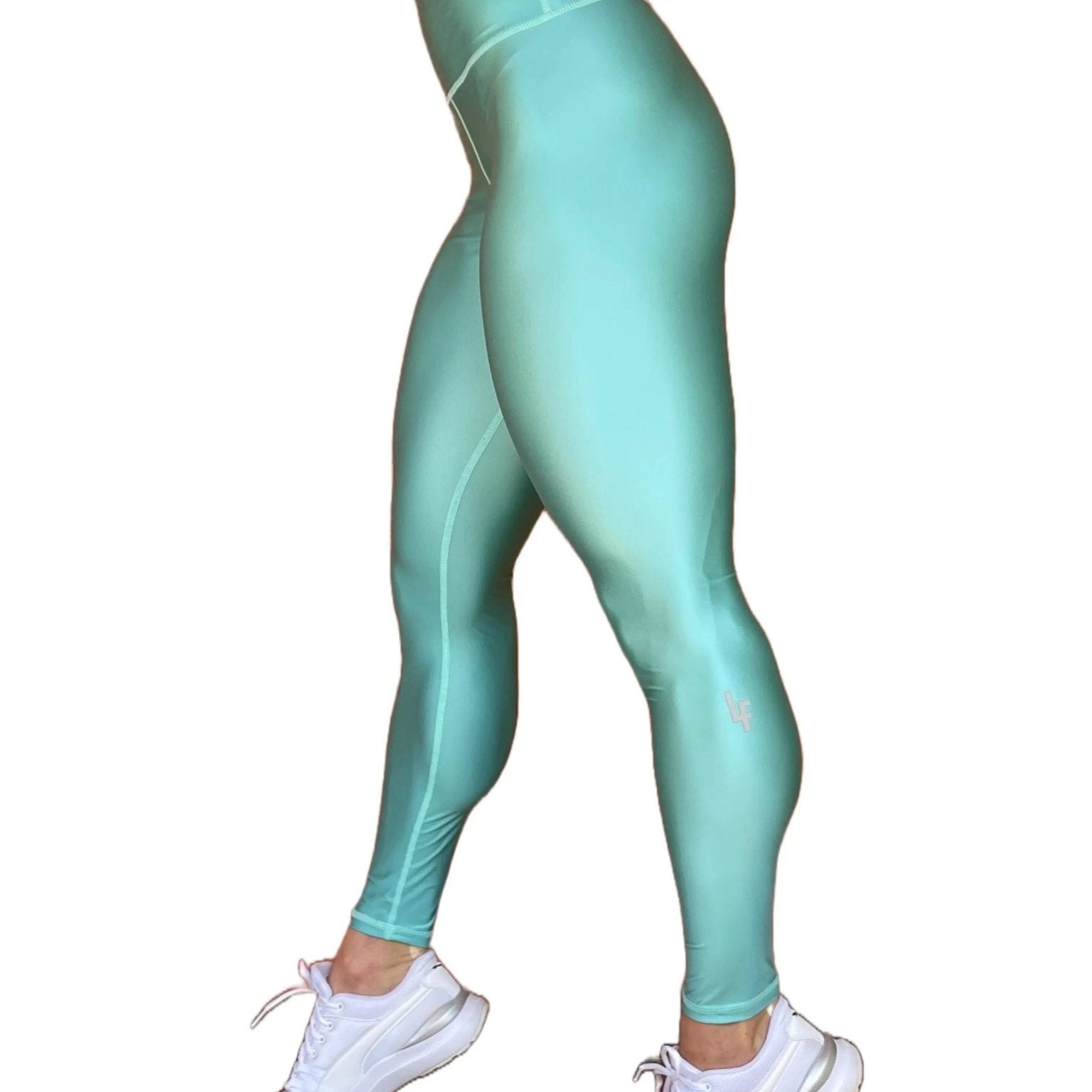 Mujer vistiendo los leggings brillantes de cintura alta Legging Pearl Shine de LUXFEEL en color Azul Celeste Brillante, con acabado efecto perla.