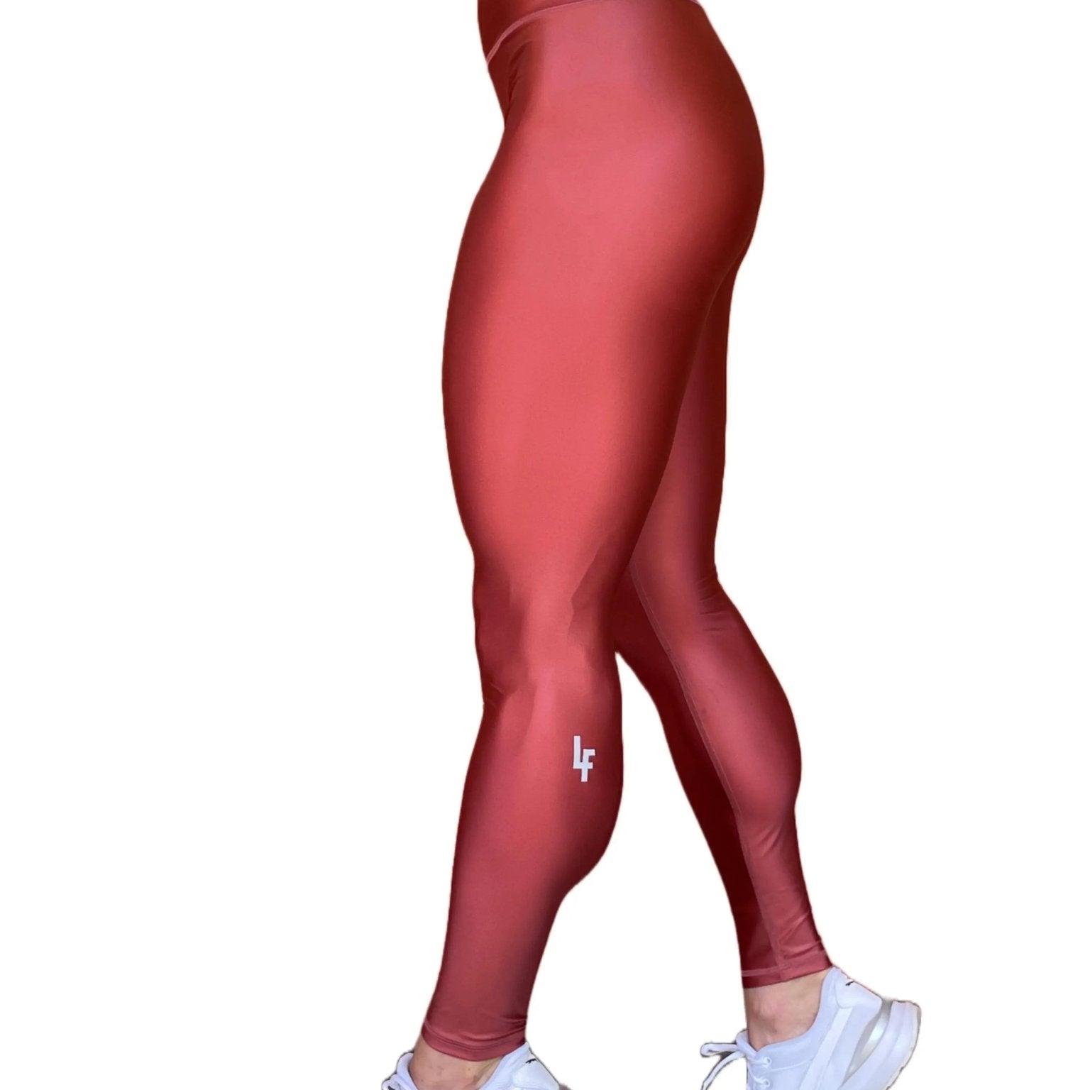 Mujer vistiendo los leggings brillantes de cintura alta Legging Pearl Shine de LUXFEEL en color Teja Brillante / Marron Brillante, con acabado efecto perla.