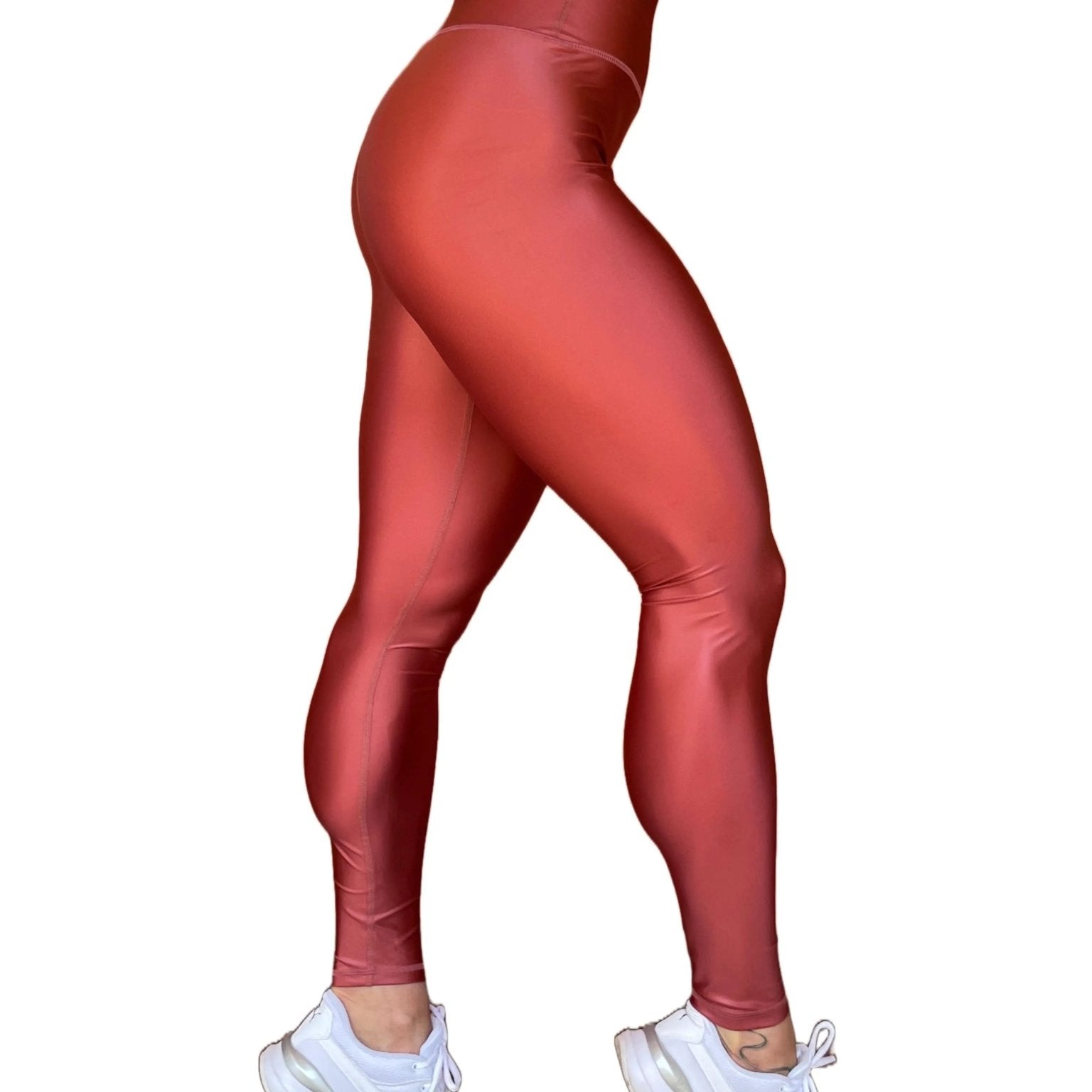 Mujer vistiendo los leggings brillantes de cintura alta Legging Pearl Shine de LUXFEEL en color Teja Brillante / Marron Brillante, con acabado efecto perla.