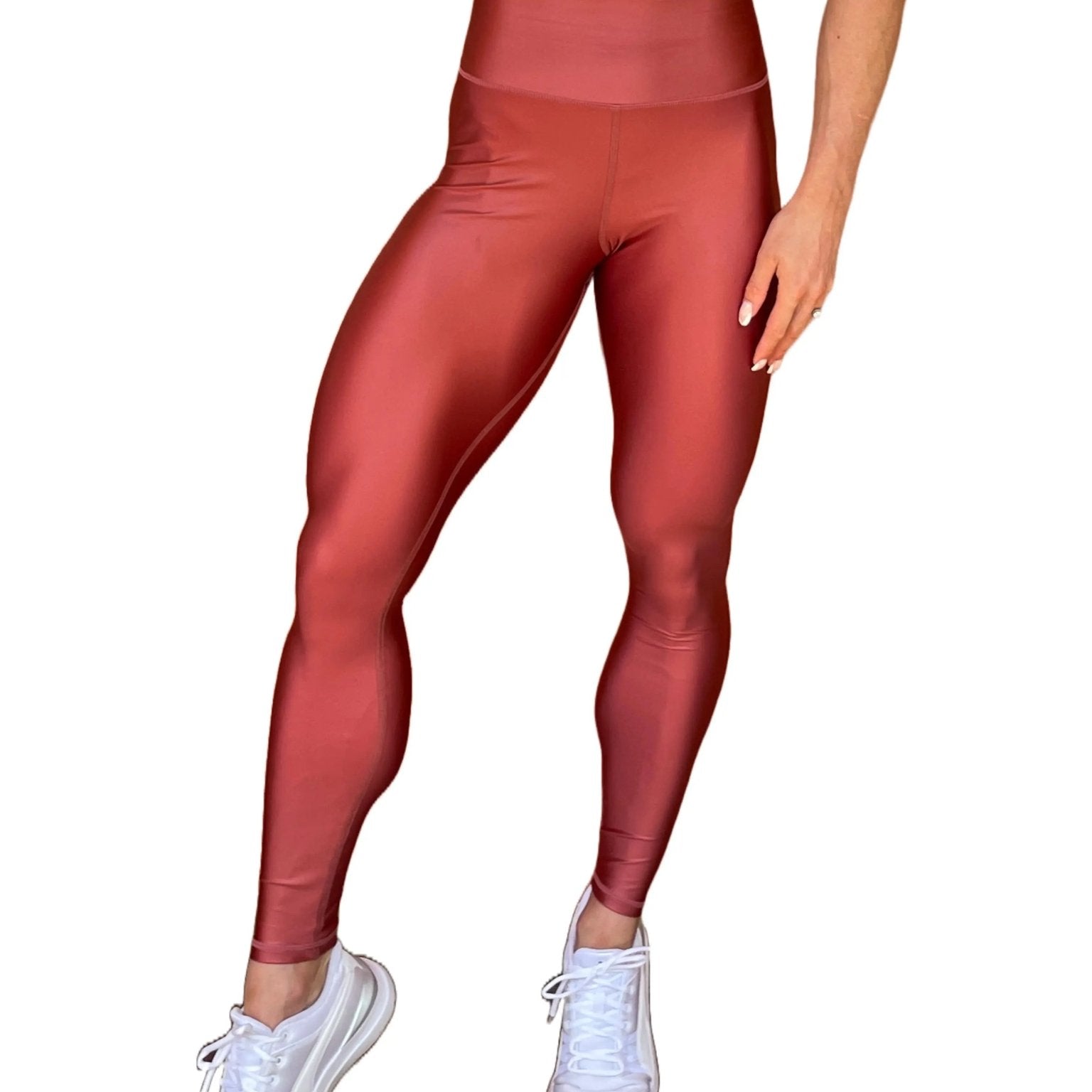 Mujer vistiendo los leggings brillantes de cintura alta Legging Pearl Shine de LUXFEEL en color Teja Brillante / Marron Brillante, con acabado efecto perla.