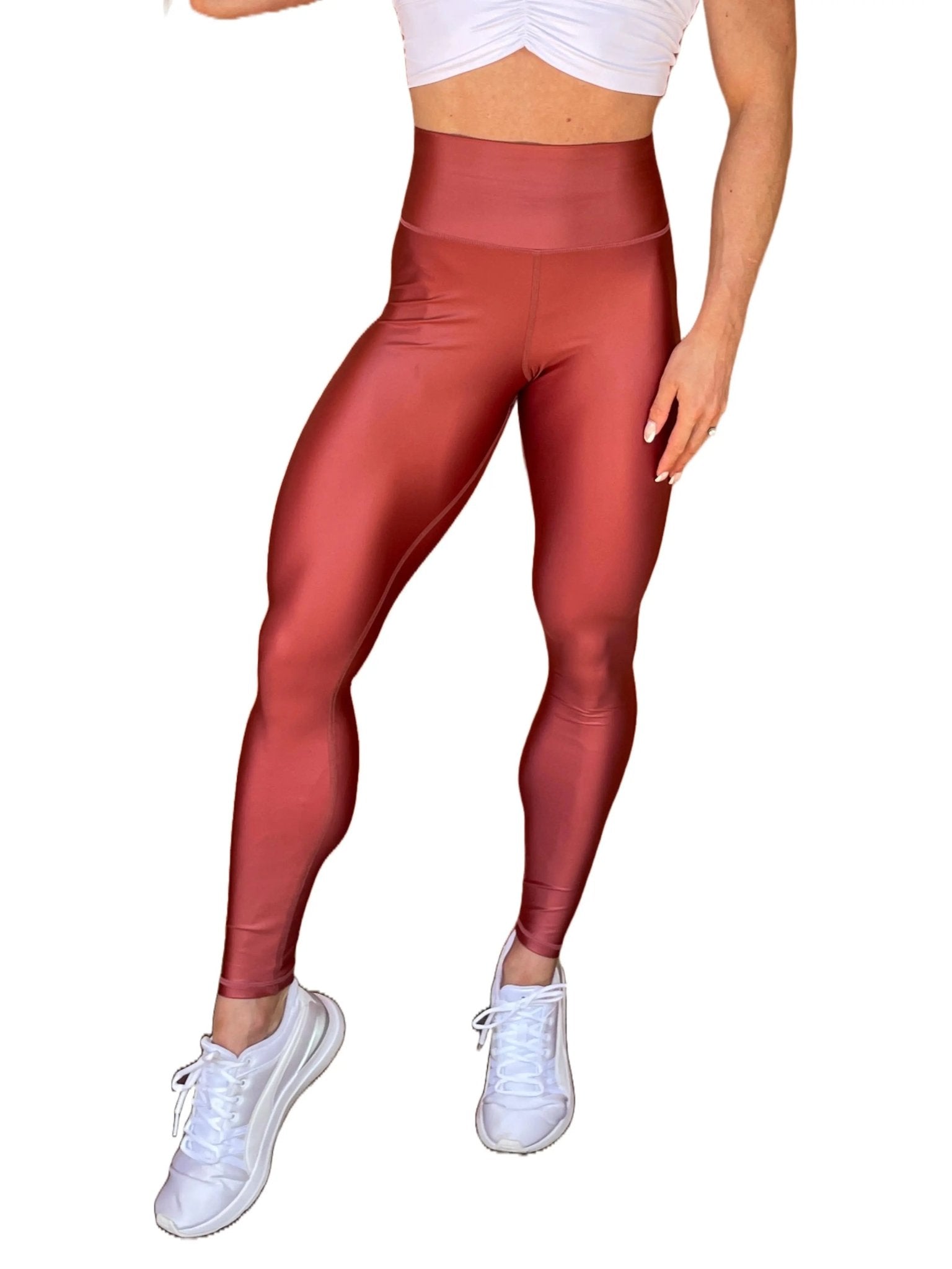 Mujer vistiendo los leggings brillantes de cintura alta Legging Pearl Shine de LUXFEEL en color Teja Brillante / Marron Brillante, con acabado efecto perla.
