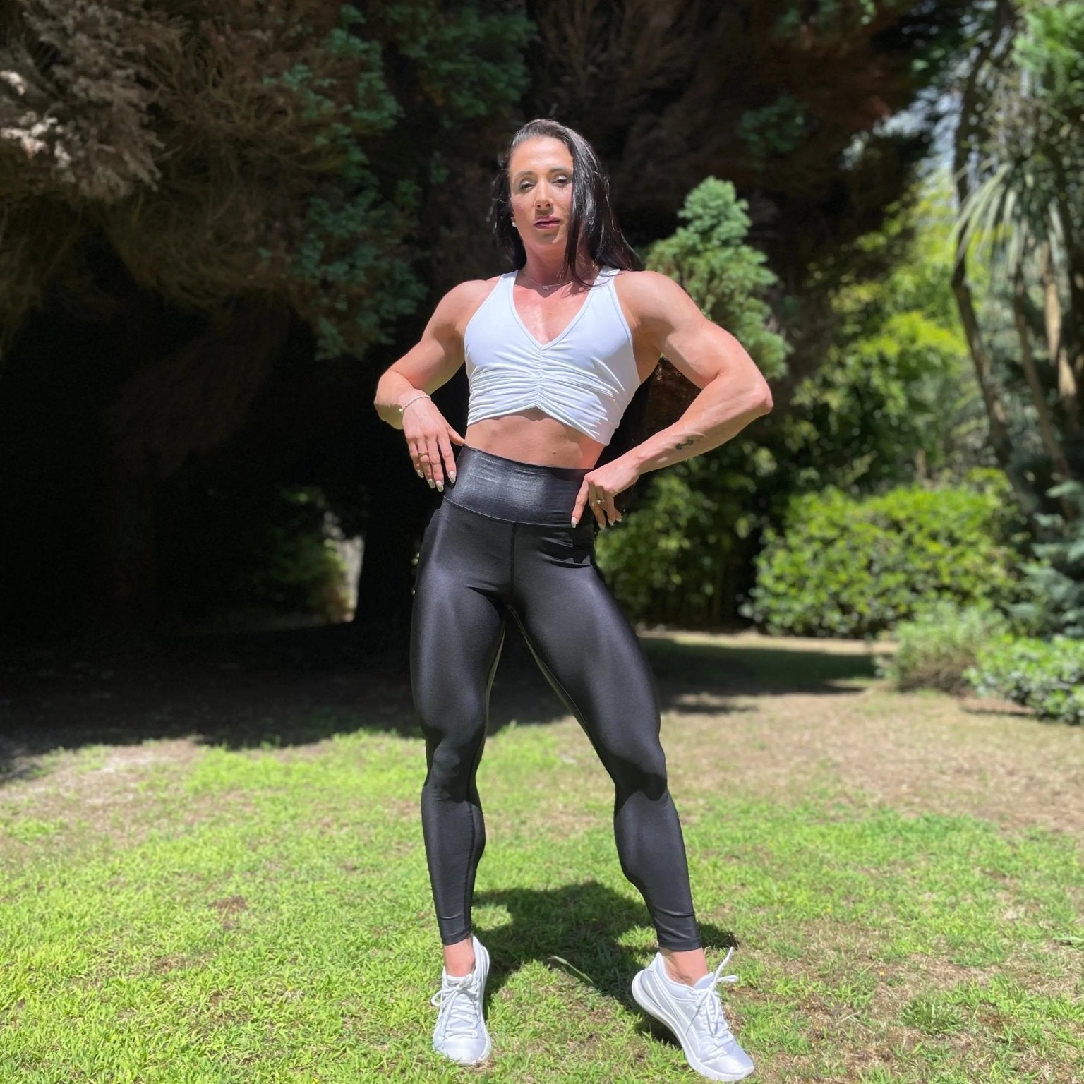 Mujer vistiendo los leggings brillantes de cintura alta Legging Pearl Shine de LUXFEEL en color Negro Brillante, con acabado efecto perla.