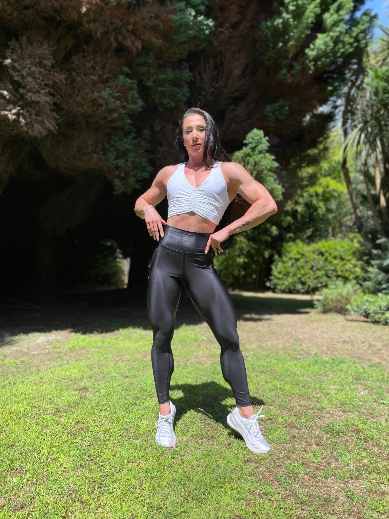 Mujer vistiendo los leggings brillantes de cintura alta Legging Pearl Shine de LUXFEEL en color Negro Brillante, con acabado efecto perla.