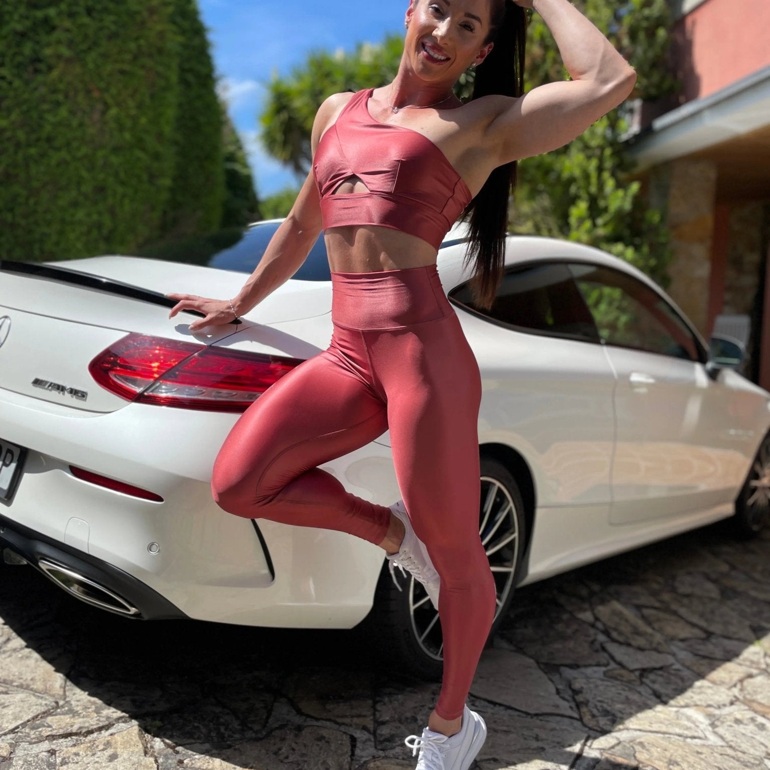 Mujer vistiendo los leggings brillantes de cintura alta Legging Pearl Shine de LUXFEEL en color Teja Brillante / Marron Brillante, con acabado efecto perla.