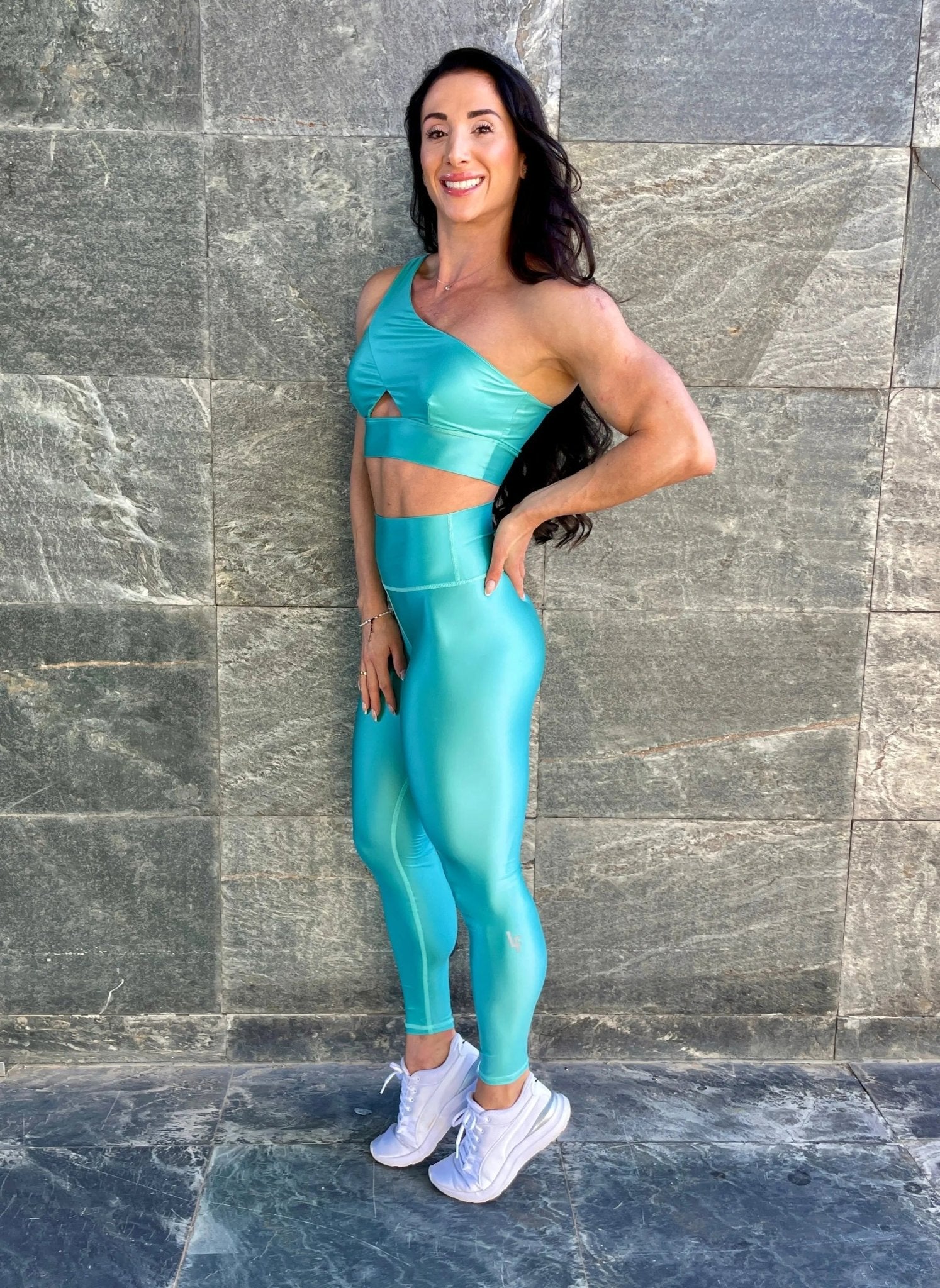 Mujer vistiendo los leggings brillantes de cintura alta Legging Pearl Shine de LUXFEEL en color Azul Celeste Brillante, con acabado efecto perla.