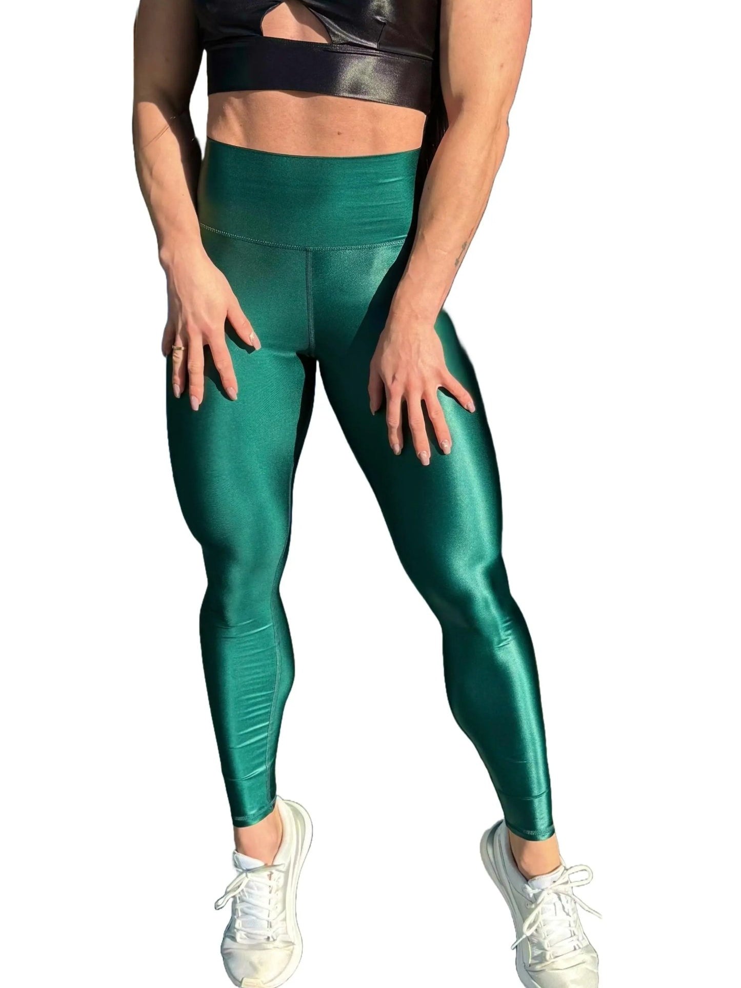 Mujer vistiendo los leggings brillantes de cintura alta Legging Pearl Shine de LUXFEEL en color Verde Botella Brillante, con acabado efecto perla.