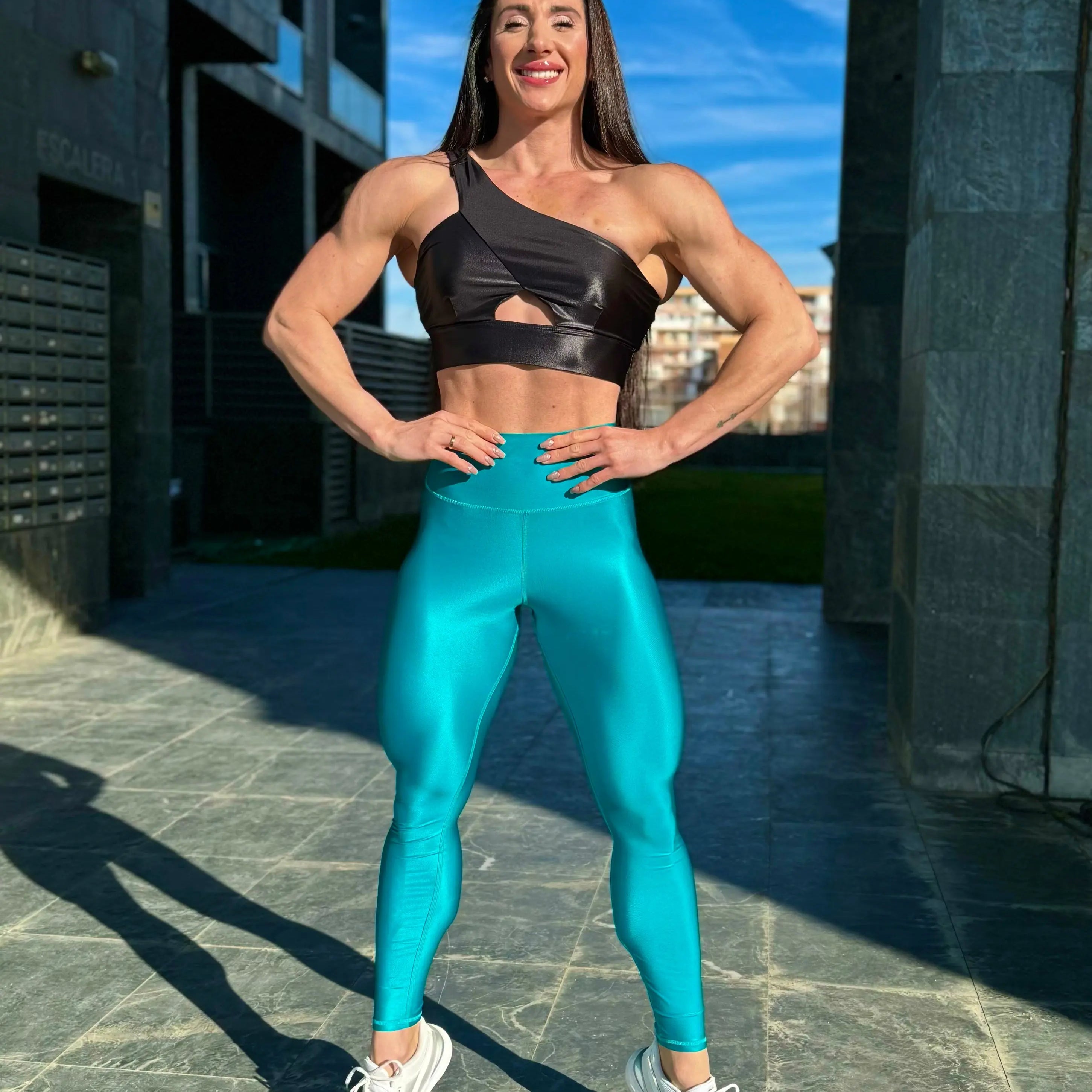 Mujer vistiendo los leggings brillantes de cintura alta Legging Pearl Shine de LUXFEEL en color Azul Capri Brillante, con acabado efecto perla.