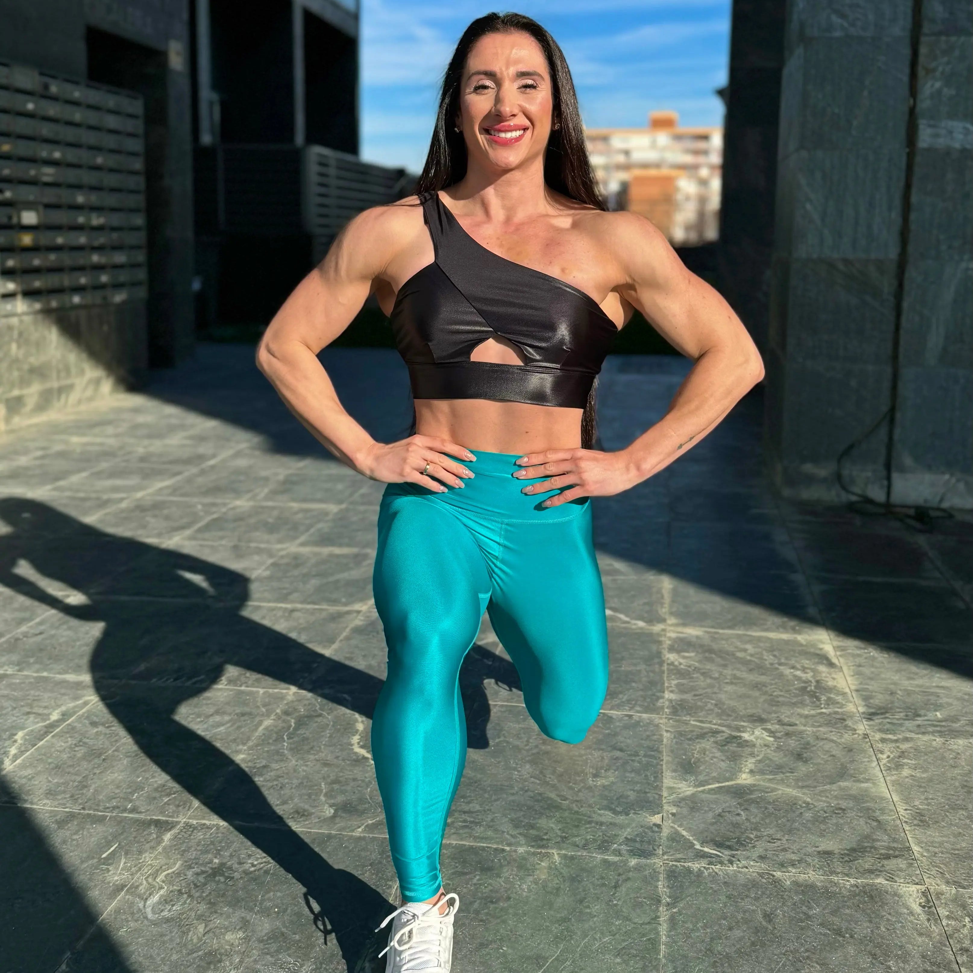 Mujer vistiendo los leggings brillantes de cintura alta Legging Pearl Shine de LUXFEEL en color Azul Capri Brillante, con acabado efecto perla.