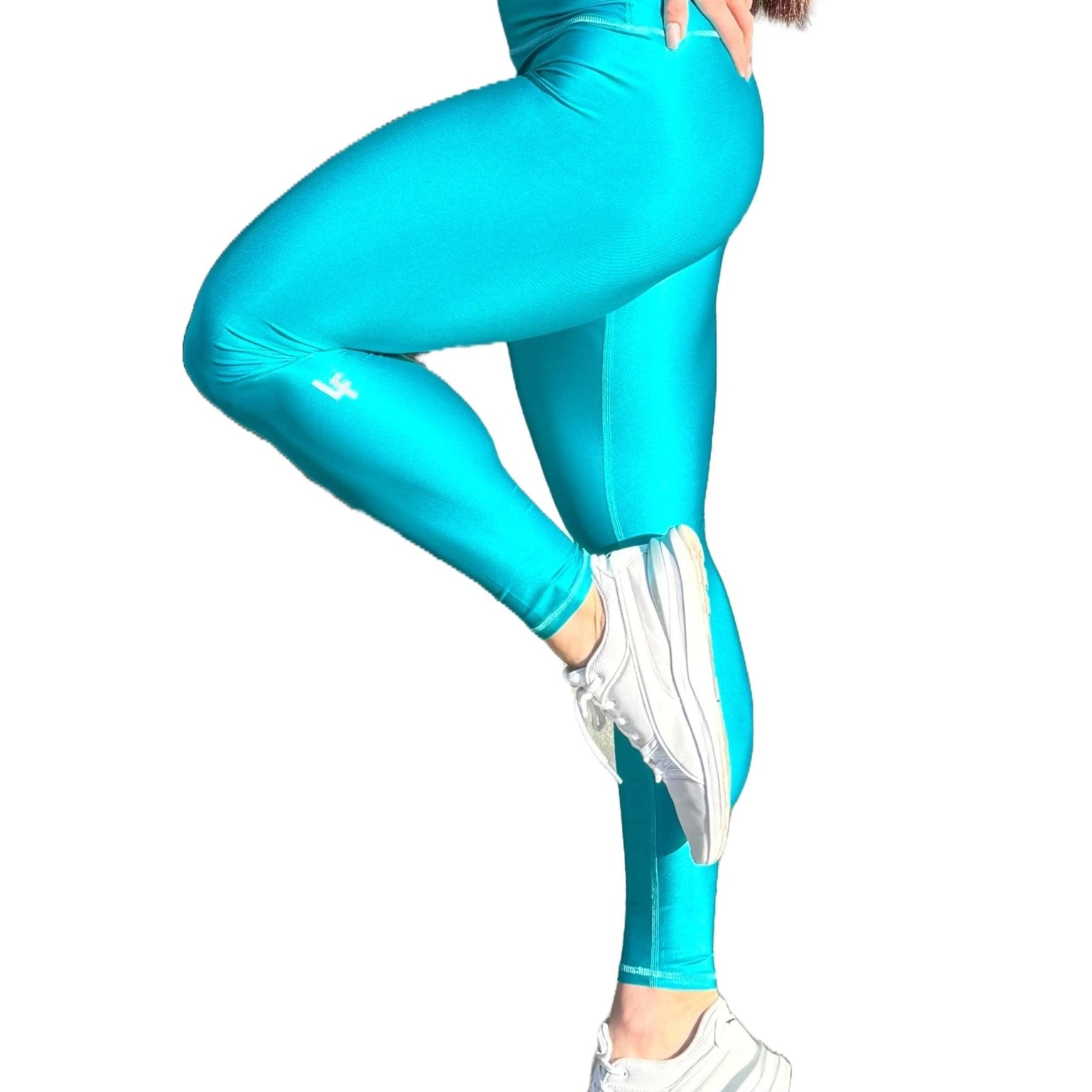 Mujer vistiendo los leggings brillantes de cintura alta Legging Pearl Shine de LUXFEEL en color Azul Capri Brillante, con acabado efecto perla.