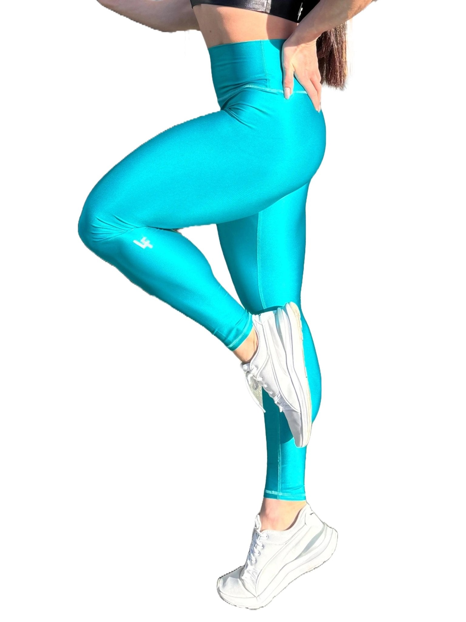 Mujer vistiendo los leggings brillantes de cintura alta Legging Pearl Shine de LUXFEEL en color Azul Capri Brillante, con acabado efecto perla.