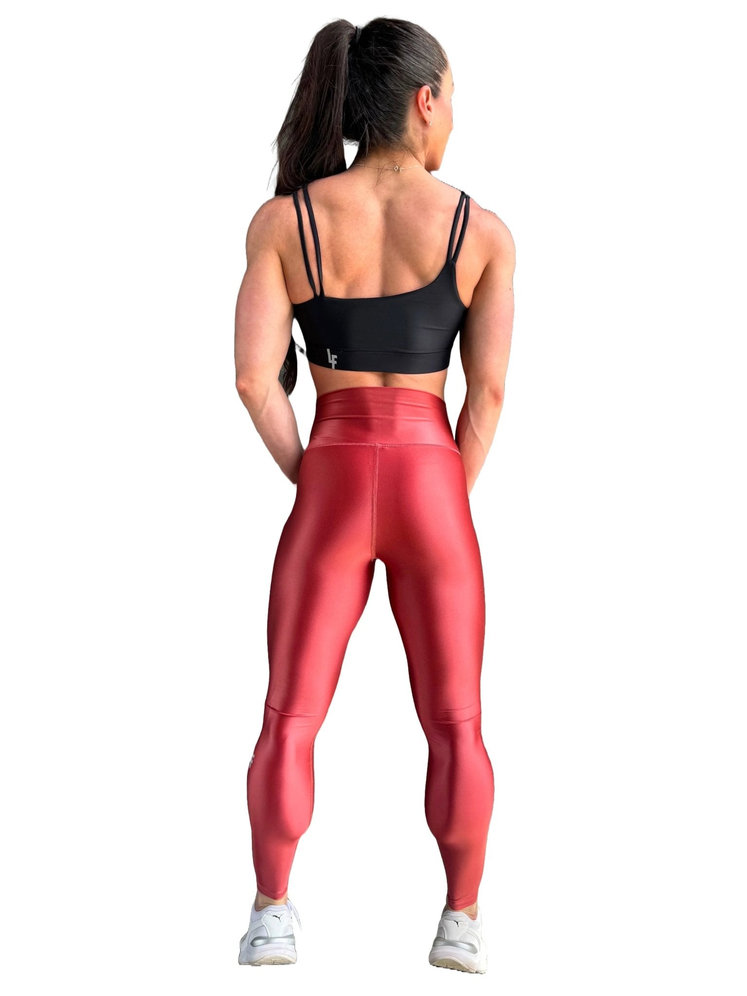Mujer vistiendo los leggings brillantes de cintura alta Legging Pearl Shine de LUXFEEL en color Teja Brillante / Marron Brillante, con acabado efecto perla.