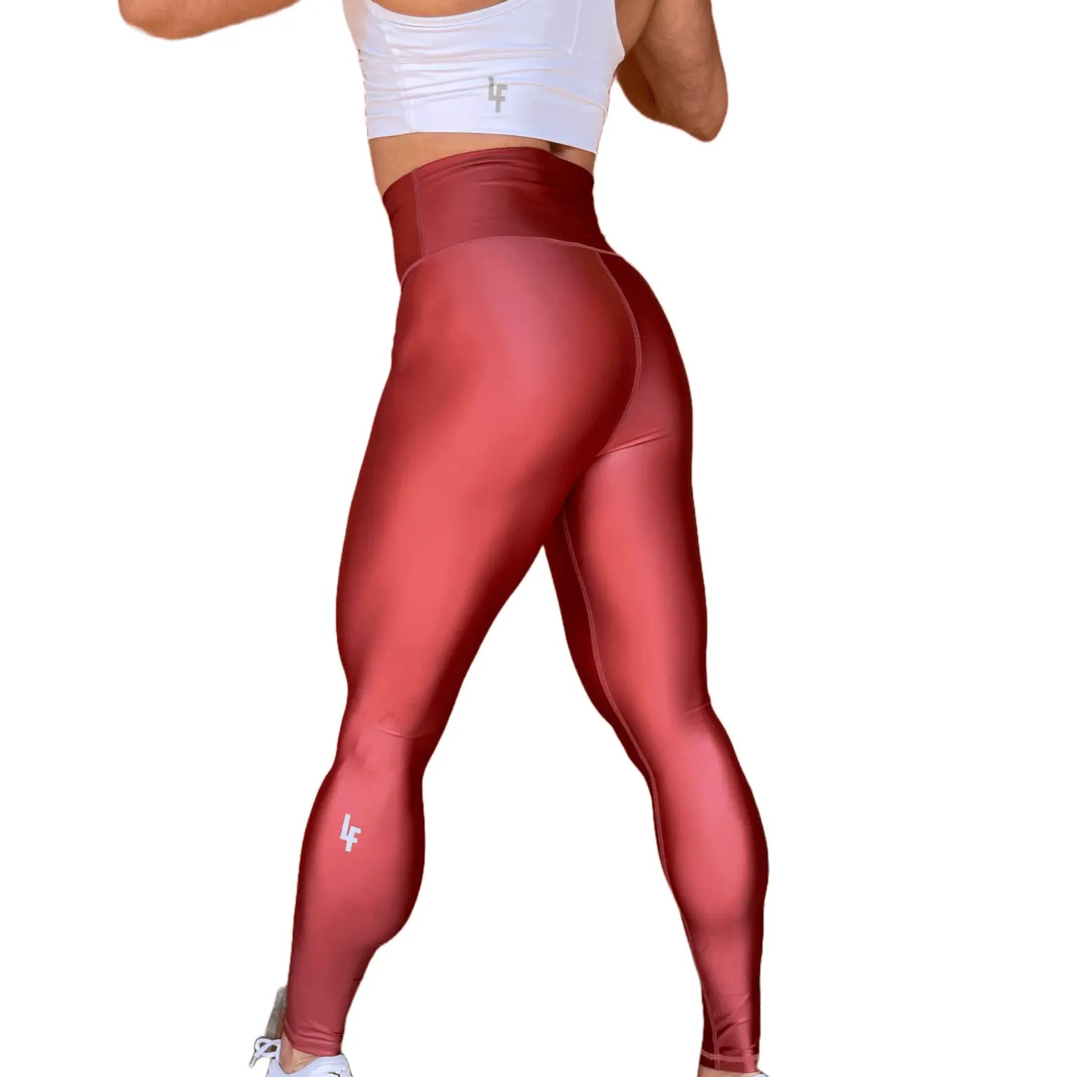 Mujer vistiendo los leggings brillantes de cintura alta Legging Pearl Shine de LUXFEEL en color Teja Brillante / Marron Brillante, con acabado efecto perla.