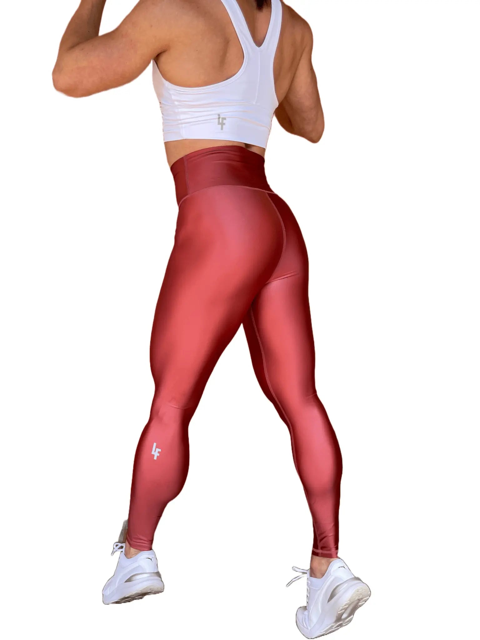 Mujer vistiendo los leggings brillantes de cintura alta Legging Pearl Shine de LUXFEEL en color Teja Brillante / Marron Brillante, con acabado efecto perla.