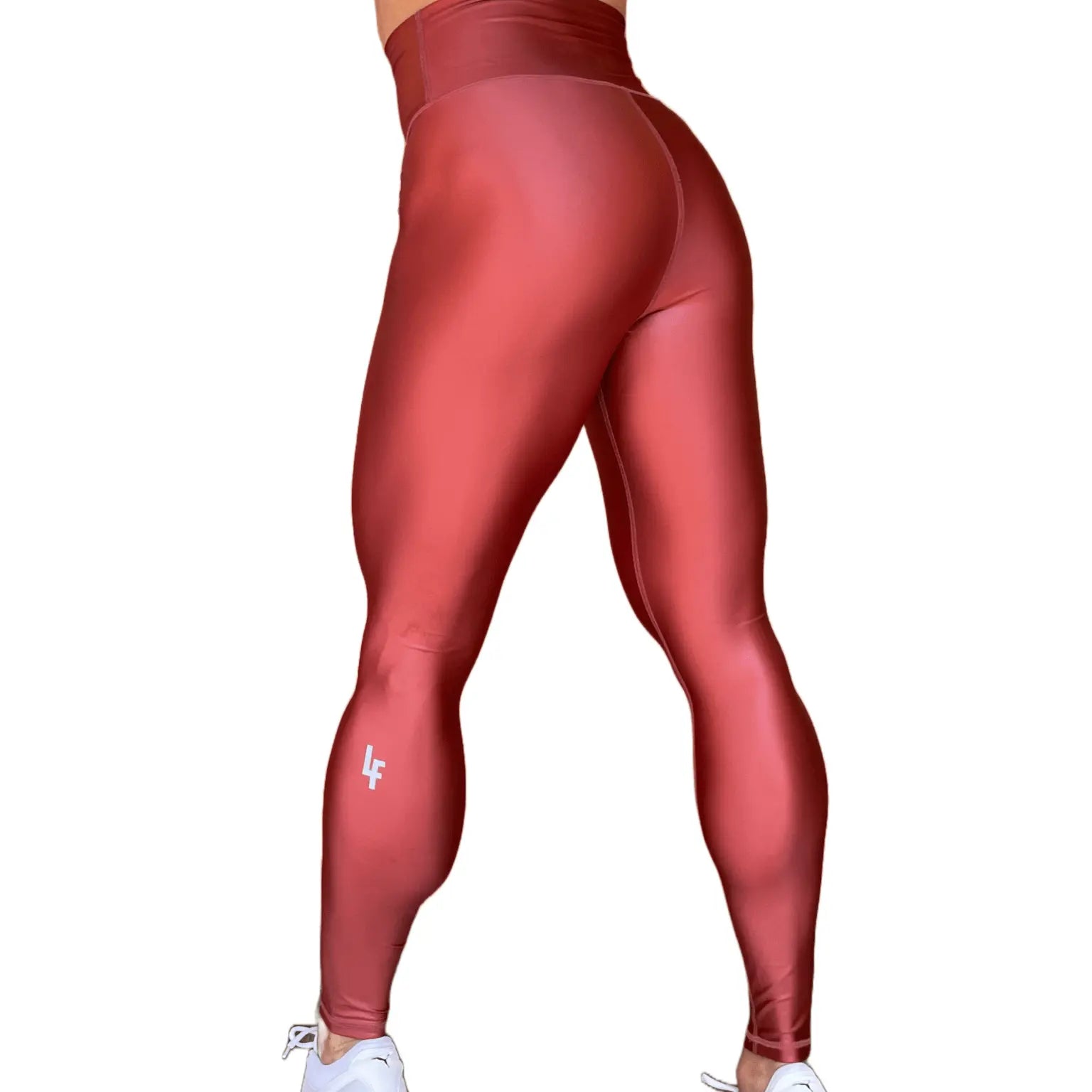 Mujer vistiendo los leggings brillantes de cintura alta Legging Pearl Shine de LUXFEEL en color Teja Brillante / Marron Brillante, con acabado efecto perla.