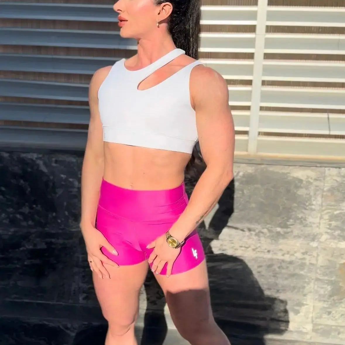 Mujer vistiendo el short deportivo de cintura alta Short Myself de LUXFEEL en color Rosa Bixbita, con diseño moldeador.