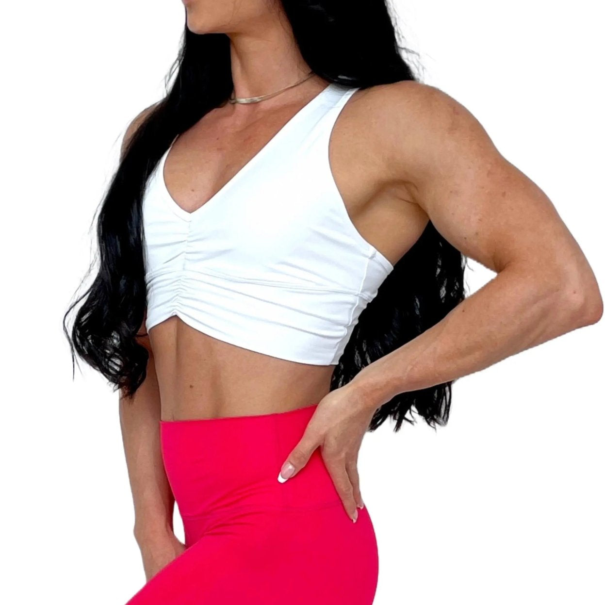 Mujer vistiendo el crop top deportivo Top Adela de LUXFEEL en color Blanco, con escote en V y detalle fruncido en el pecho.