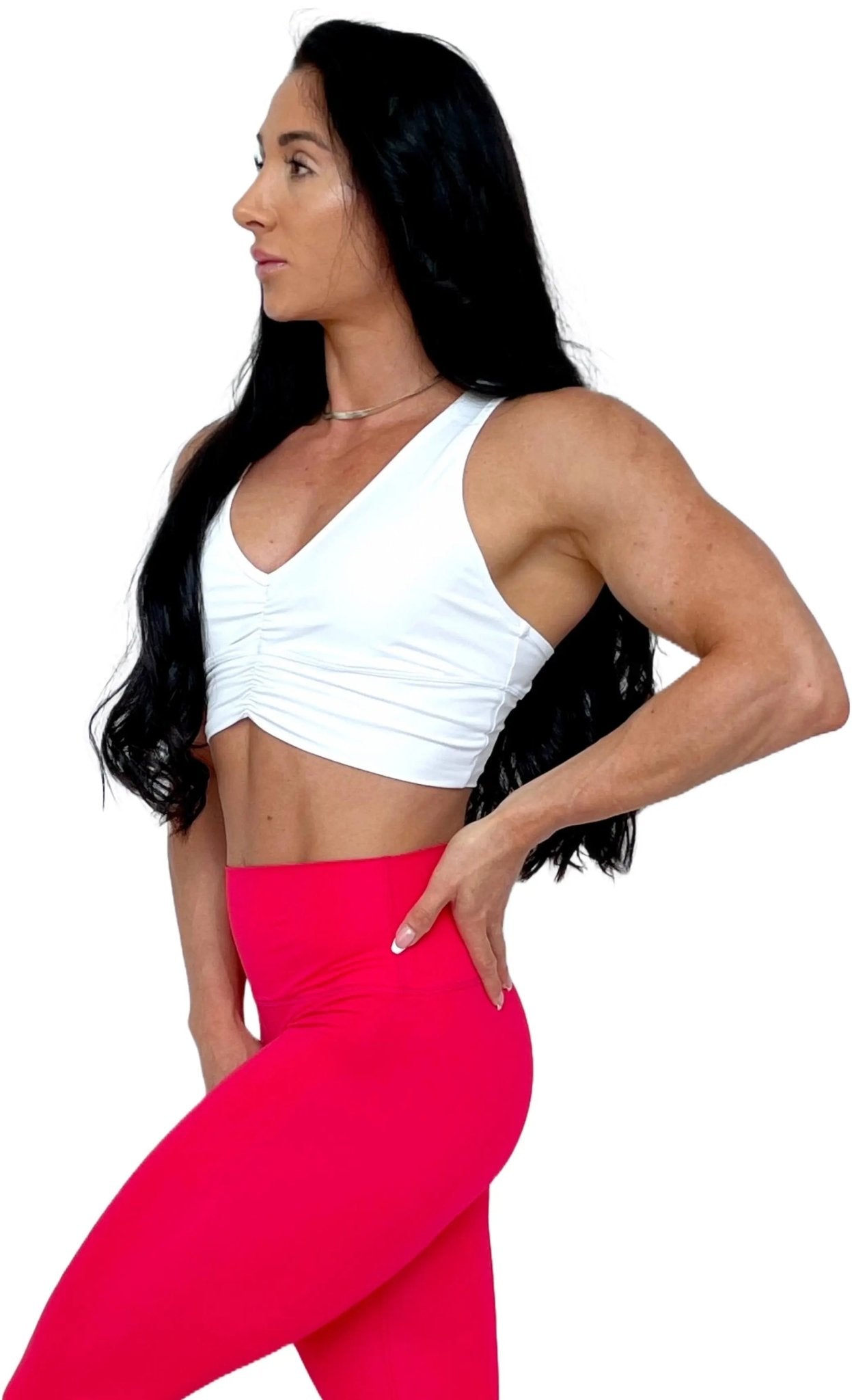 Mujer vistiendo el crop top deportivo Top Adela de LUXFEEL en color Blanco, con escote en V y detalle fruncido en el pecho.