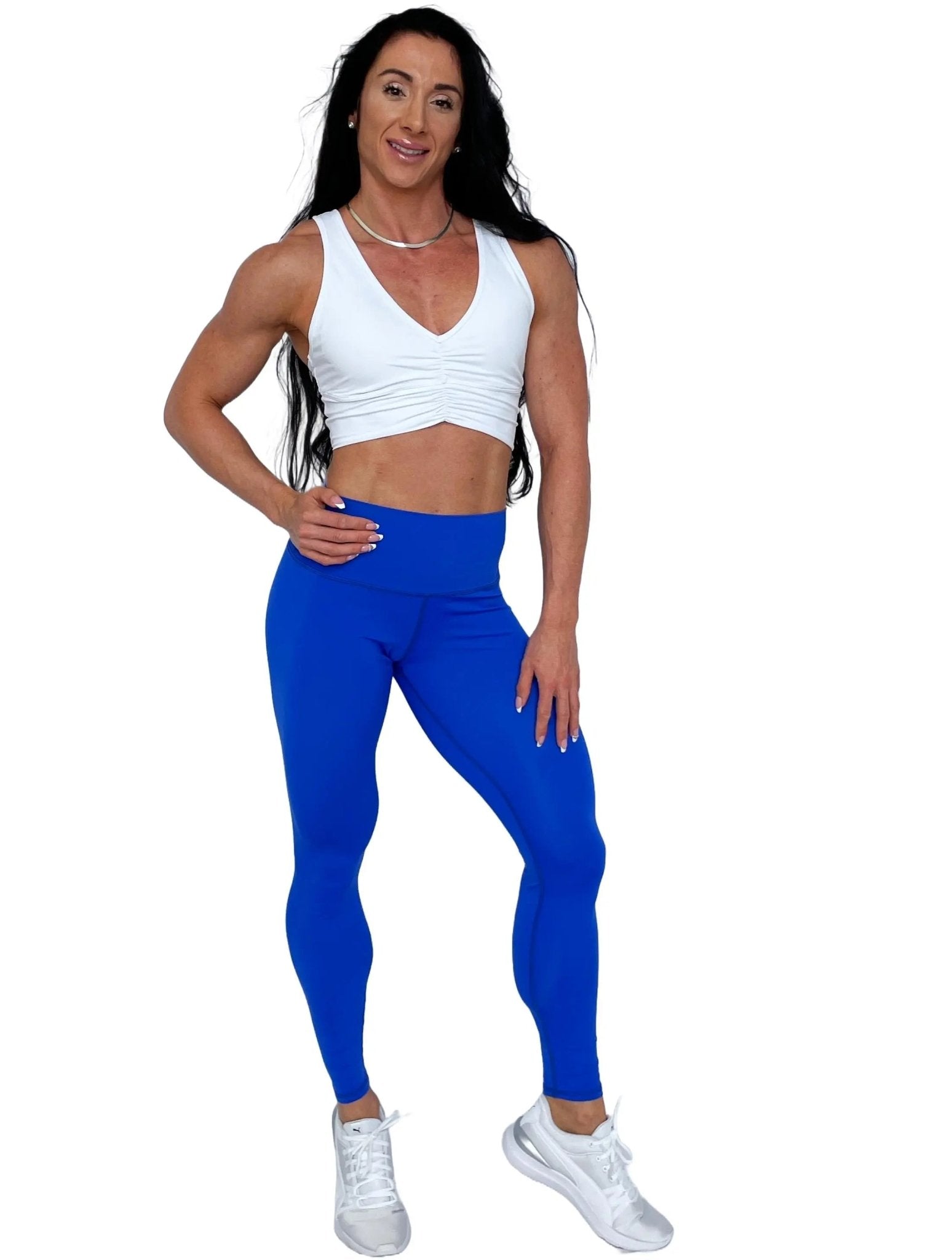 Mujer vistiendo el crop top deportivo Top Adela de LUXFEEL en color Blanco, con escote en V y detalle fruncido en el pecho.