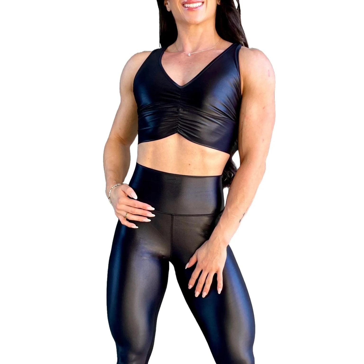 Mujer vistiendo el crop top brillante Top Adela Pearl Shine de LUXFEEL en color Negro Brillante, con escote en V y detalle fruncido en el pecho.