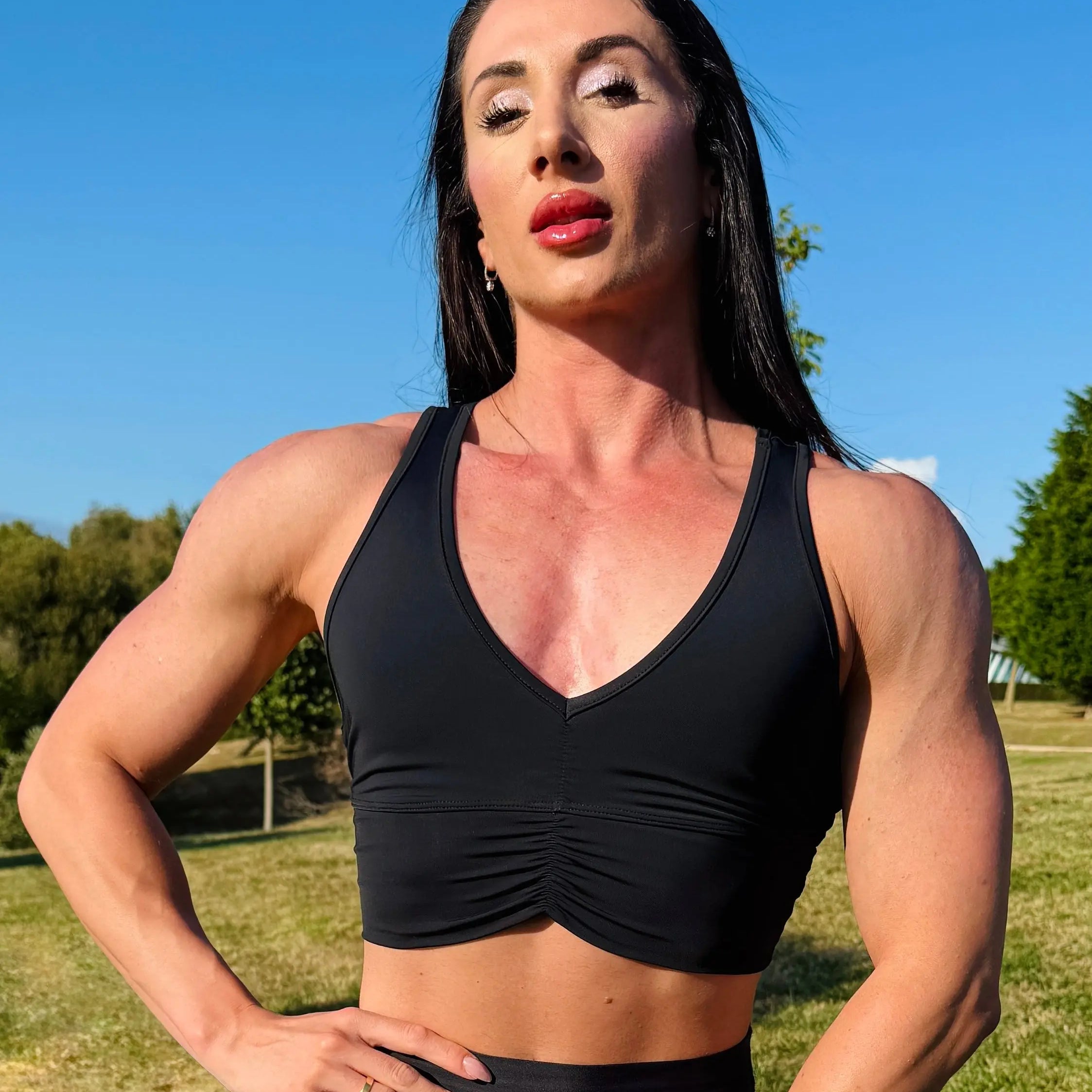 Modelo vistiendo el crop top deportivo Top Adela (de frente) de LUXFEEL en color Negro, con escote en V y detalle fruncido en el pecho.