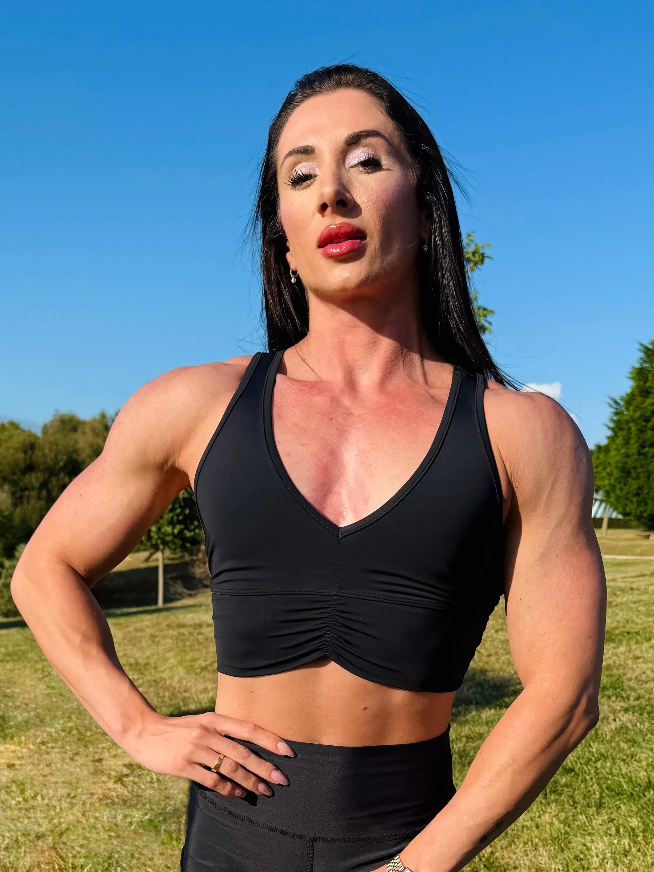 Modelo vistiendo el crop top deportivo Top Adela (de frente) de LUXFEEL en color Negro, con escote en V y detalle fruncido en el pecho.