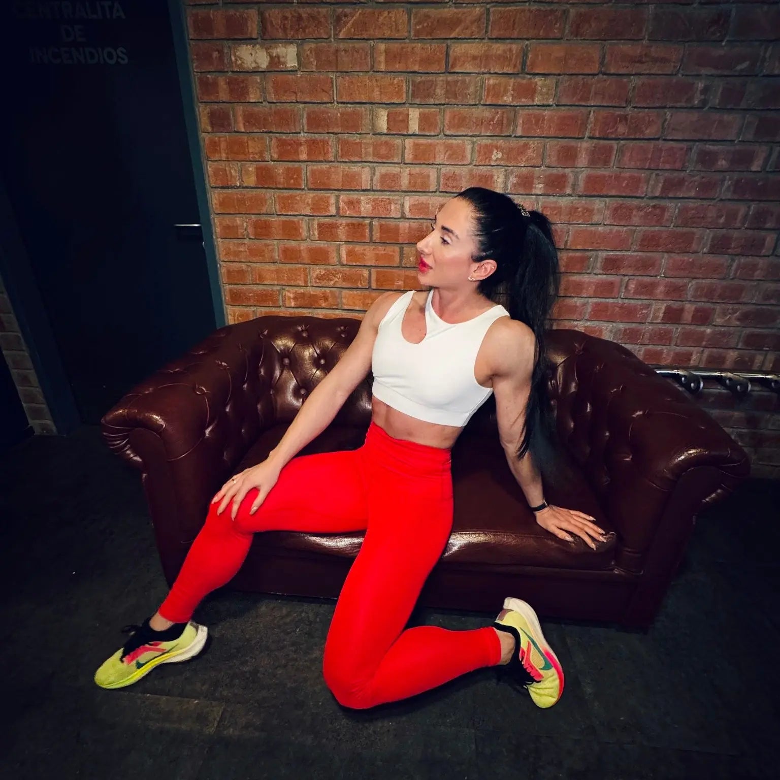 Mujer luciendo el top asimétrico Top Vanesa de LUXFEEL en color Blanco, con un diseño de apertura en el hombro y soporte extra.