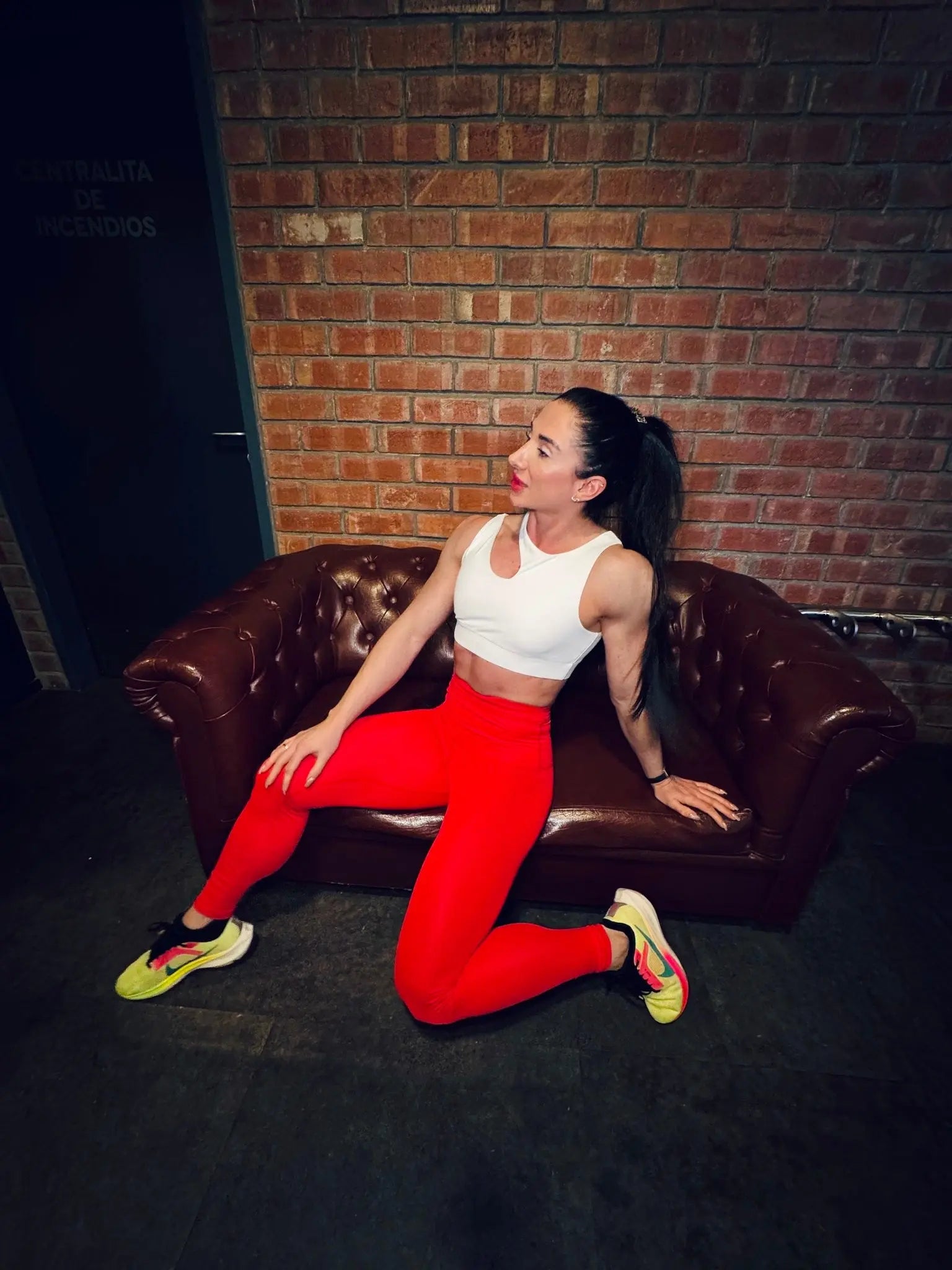 Mujer luciendo el top asimétrico Top Vanesa de LUXFEEL en color Blanco, con un diseño de apertura en el hombro y soporte extra.