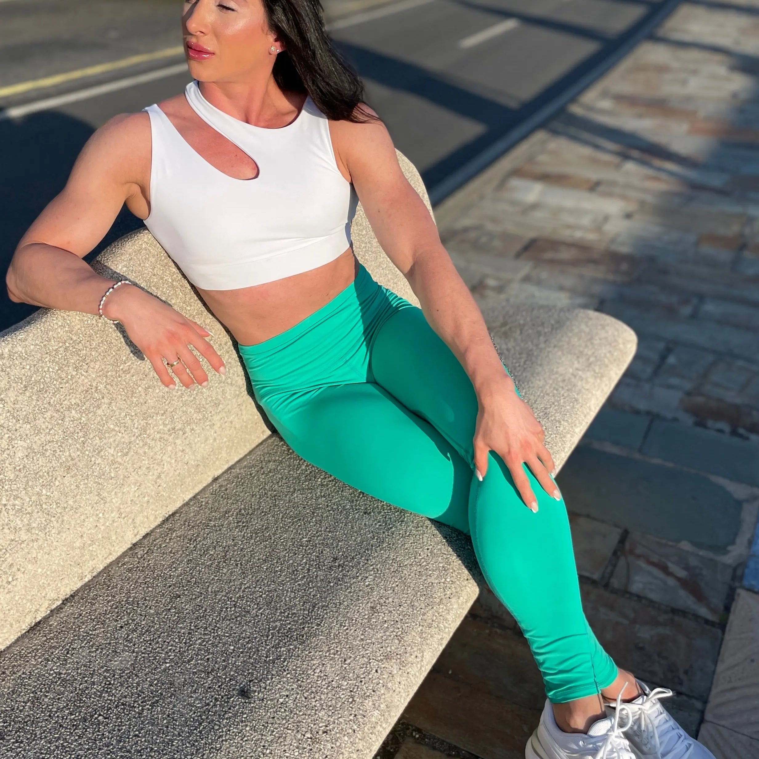 Mujer luciendo el top asimétrico Top Vanesa de LUXFEEL en color Blanco, con un diseño de apertura en el hombro y soporte extra.