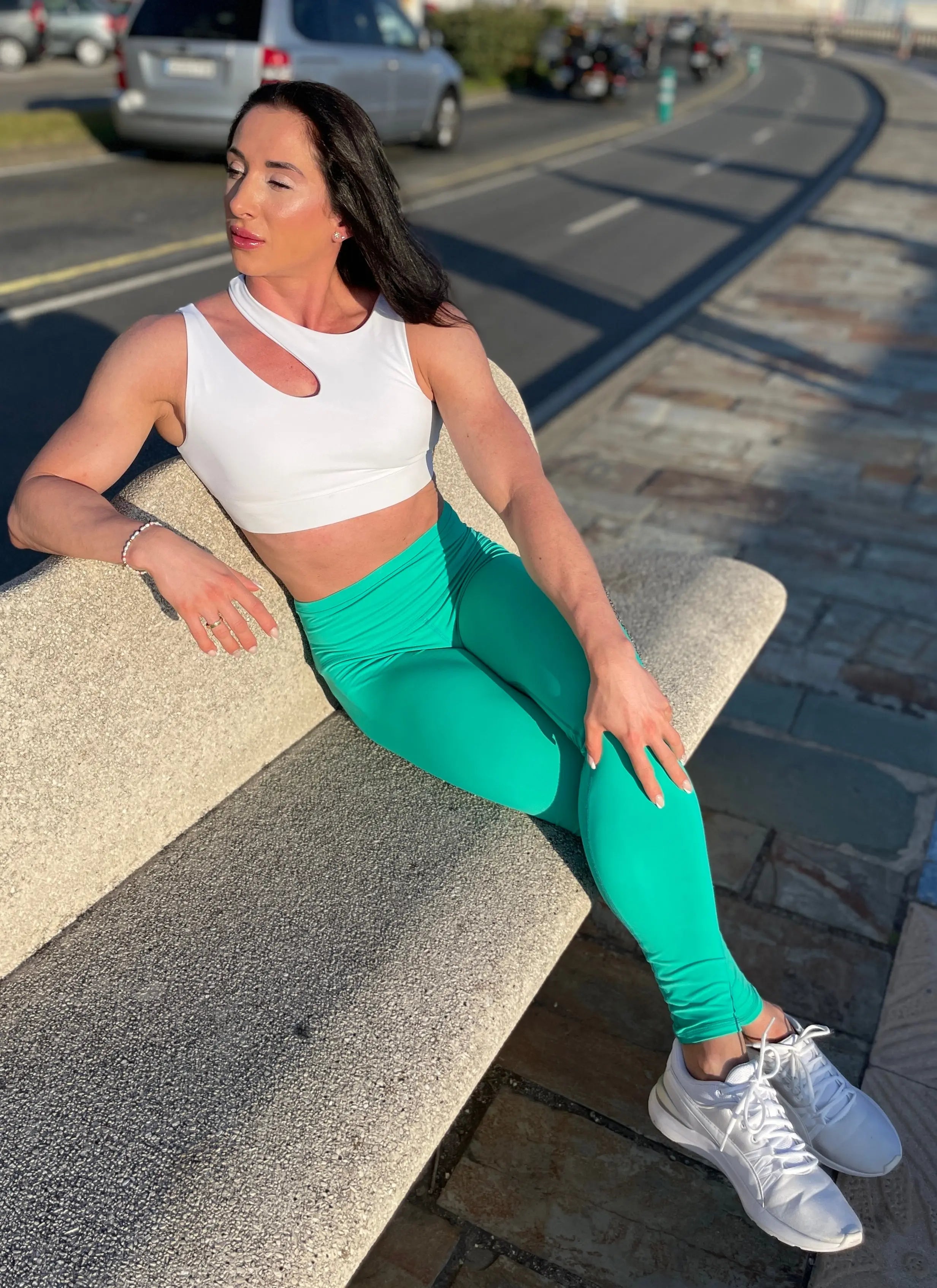 Mujer luciendo el top asimétrico Top Vanesa de LUXFEEL en color Blanco, con un diseño de apertura en el hombro y soporte extra.