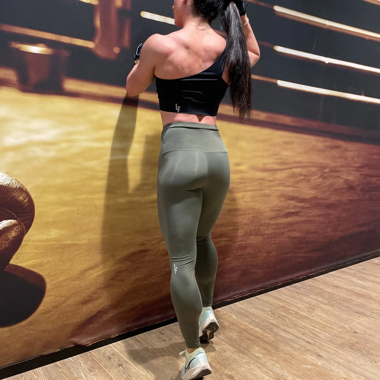 Mujer luciendo el top asimétrico Top Carmela de LUXFEEL en color Negro, con diseño de un solo hombro y apertura en el escote