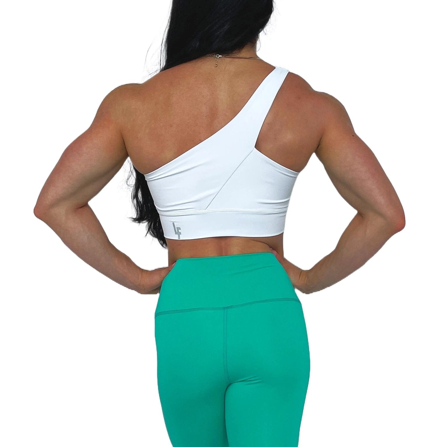 Mujer luciendo el top asimétrico Top Carmela de LUXFEEL en color Blanco, con diseño de un solo hombro y apertura en el escote